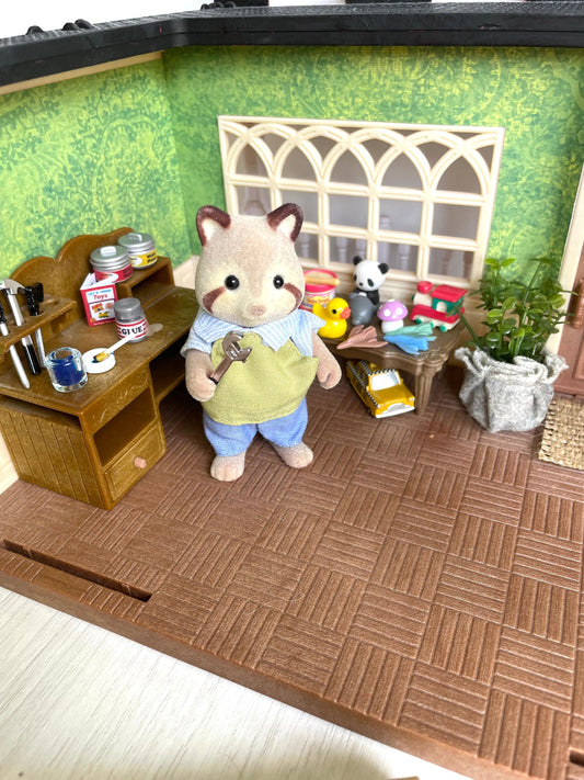 This Calico Critters toymaker set comes with a customized building with wallpaper and a painted roof. The Mulberry Racoon is in very good condition with his original toymaker outfit.