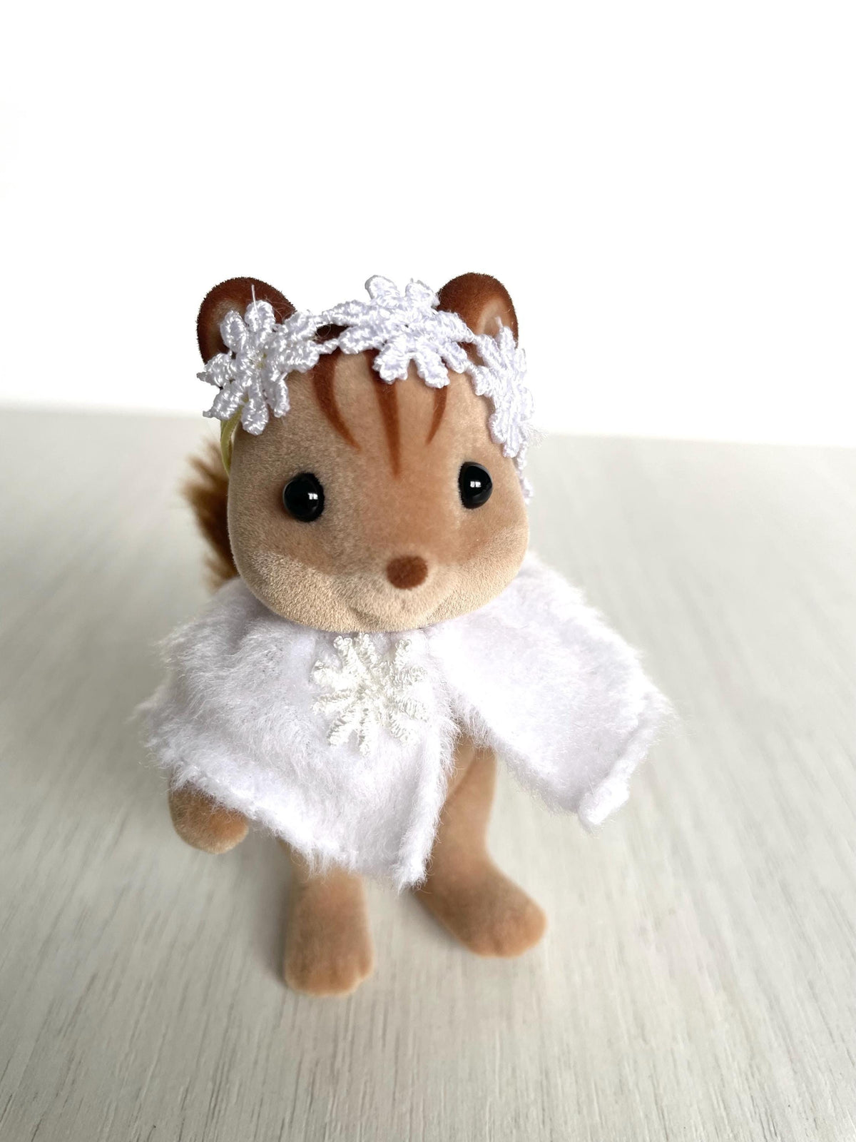 Calico Critters critter wearing white snowflake shawl and daisy flower crown, Sylvanian Families winter clothes