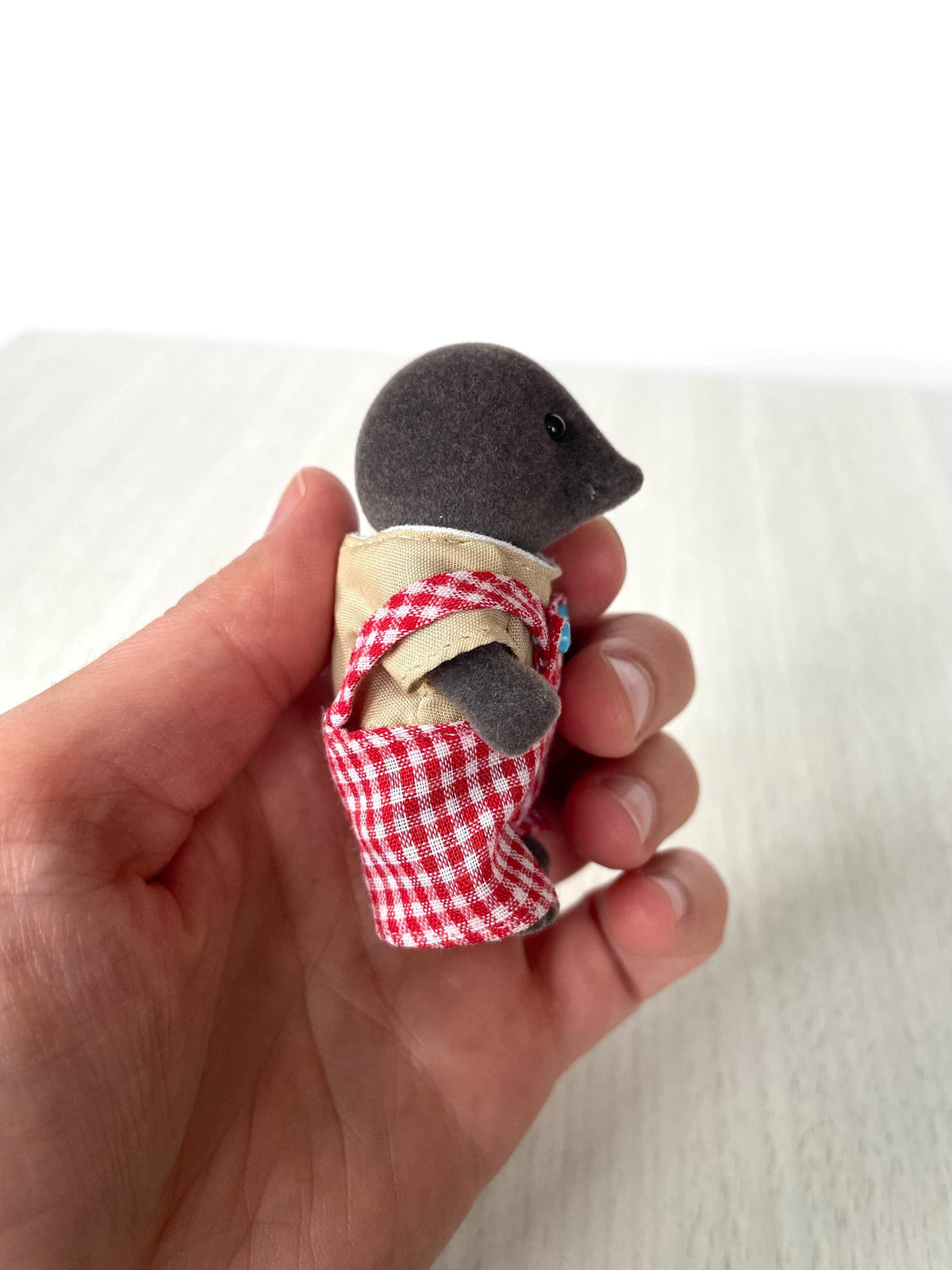 Mole dad held in hand, back three-quarter view of the red gingham overalls — Calico Critters and Sylvanian Families