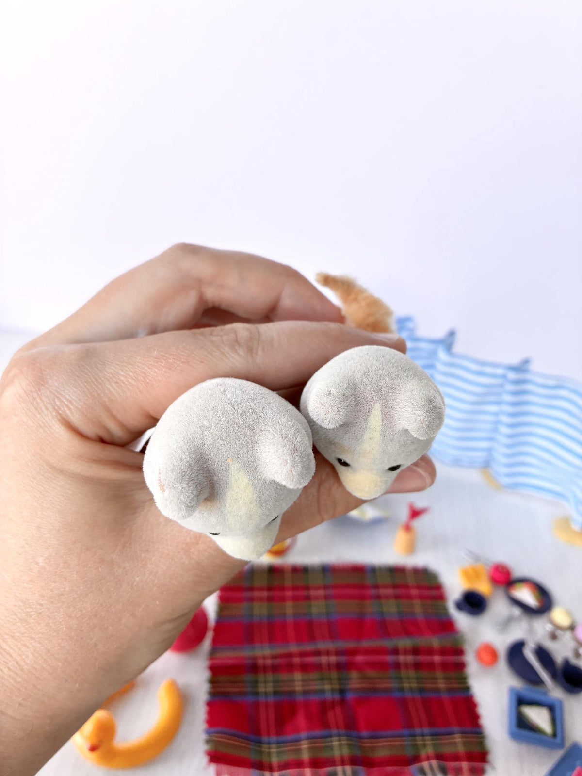 Sylvanian Families Calico Critters Day at the Seaside Set (Flair 4870): top view of both Farthing dog figures held in hand showing the cream stripe down each face and clean flocking on the ears