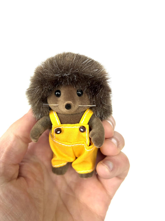 Calico Critters Sylvanian Families Pickleweeds Bramble hedgehog father in yellow dungarees, front view held in hand