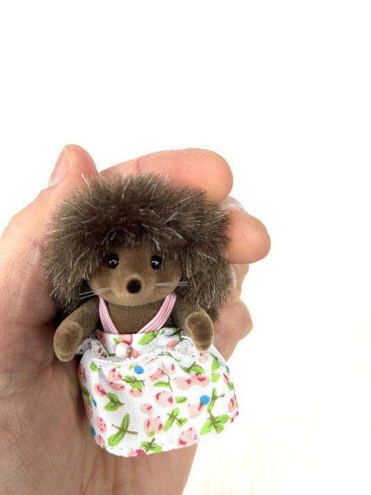 Calico Critters Sylvanian Families Pickleweeds Bramble hedgehog sister in white floral dress, front view held in hand