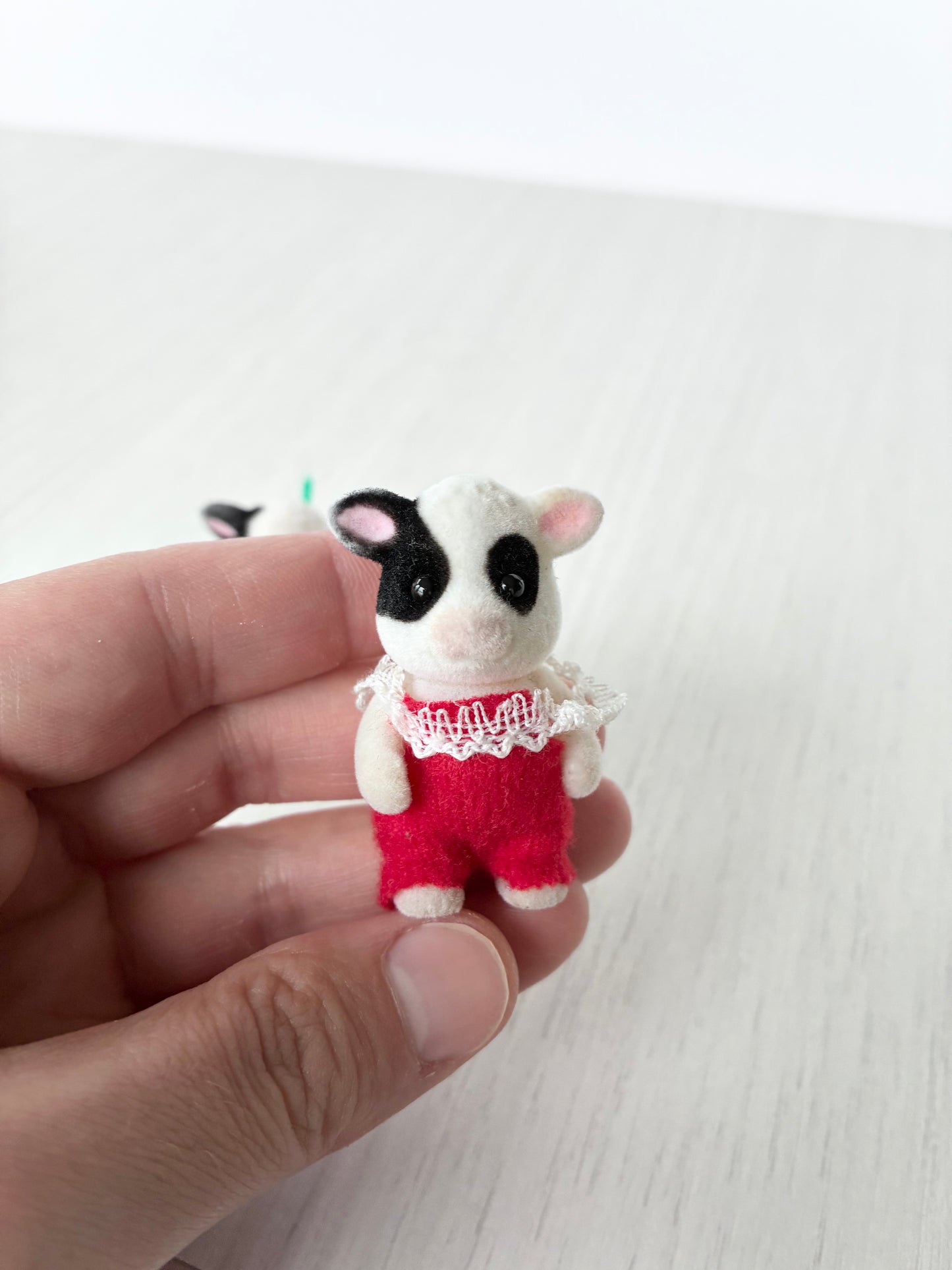 Calico Critters Sylvanian Families standing cow baby figure with articulated poseable legs, red lace romper