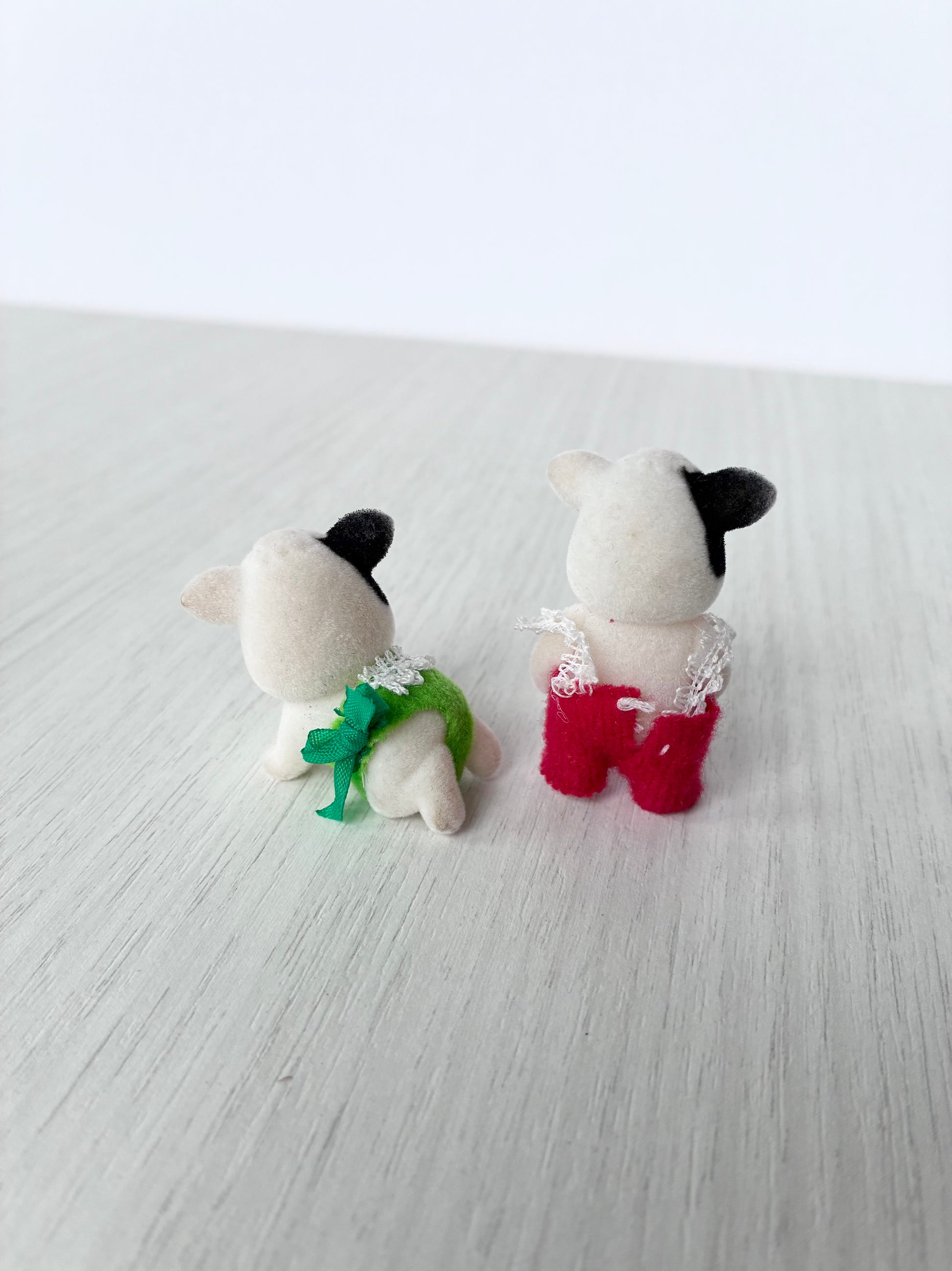 Back view of Calico Critters Sylvanian Families cow baby twins, standing articulated calf and crawling pose calf