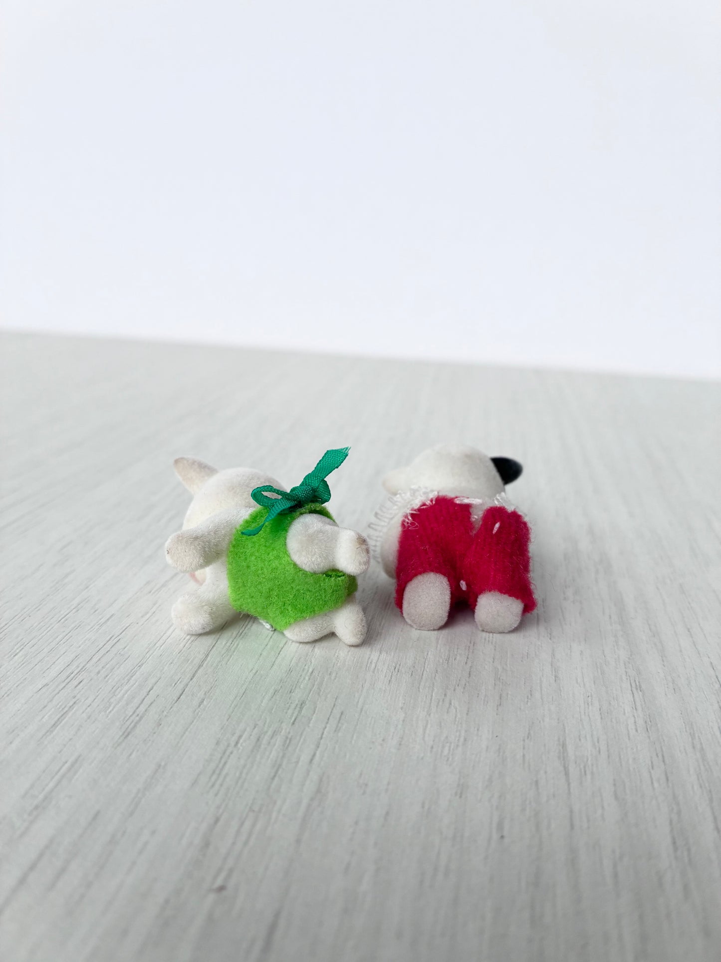 Calico Critters Sylvanian Families cow babies shown from behind, one standing on articulated joints and one in crawling pose