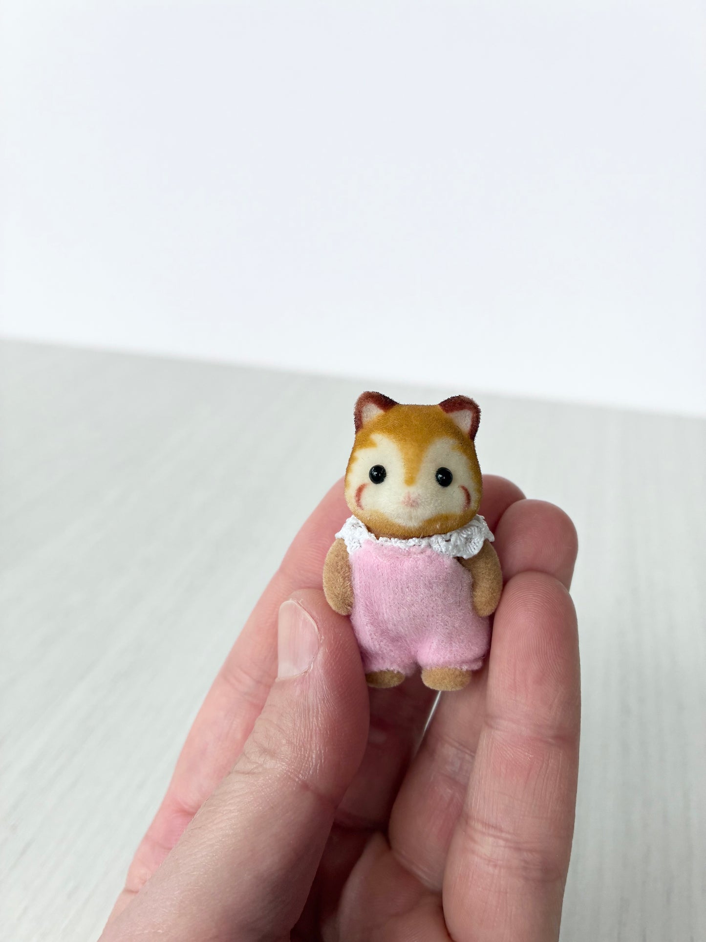 Calico Critters Sylvanian Families red panda baby held in hand for scale