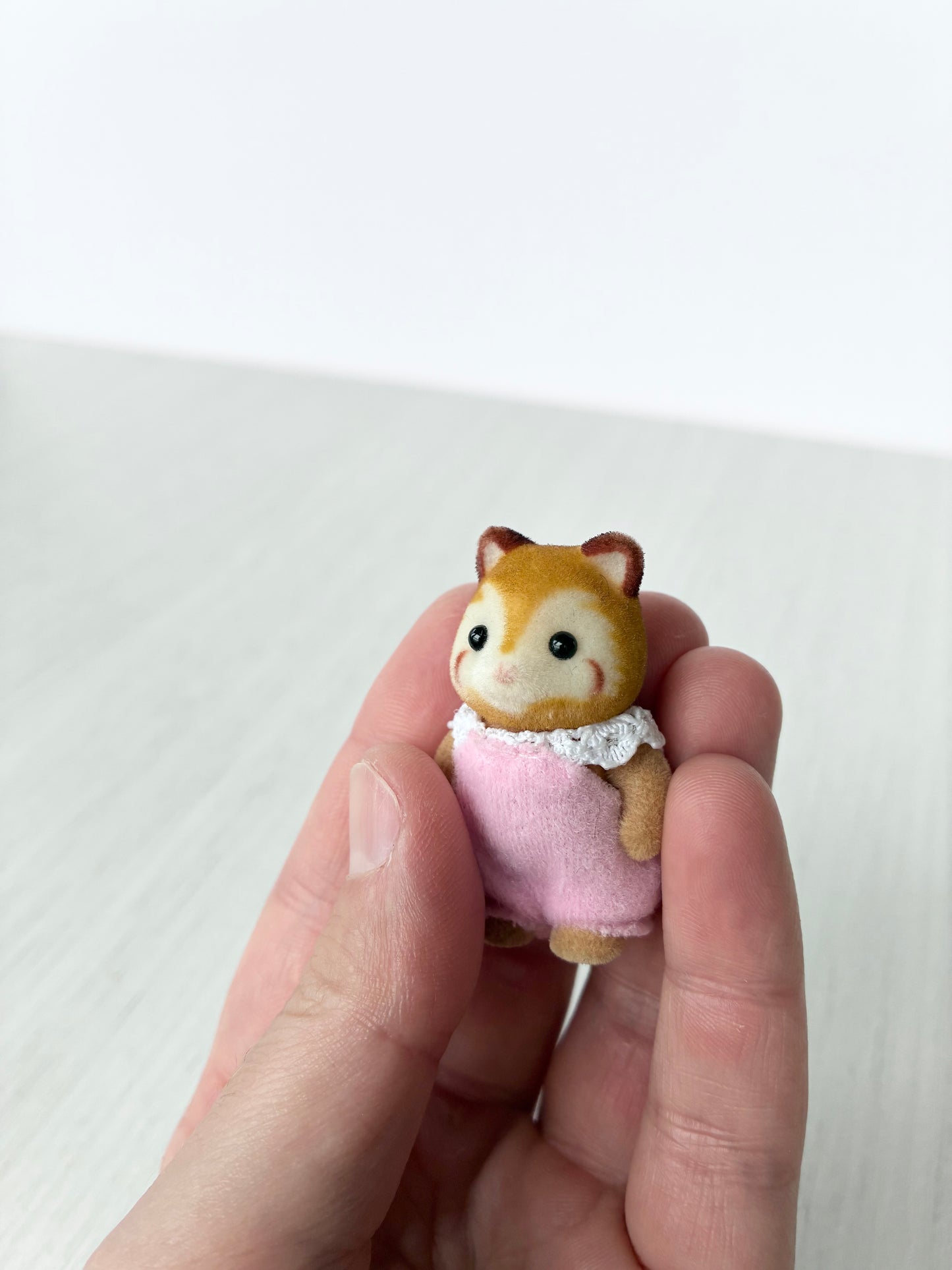 Close view of Calico Critters Sylvanian Families red panda baby in lace collar romper