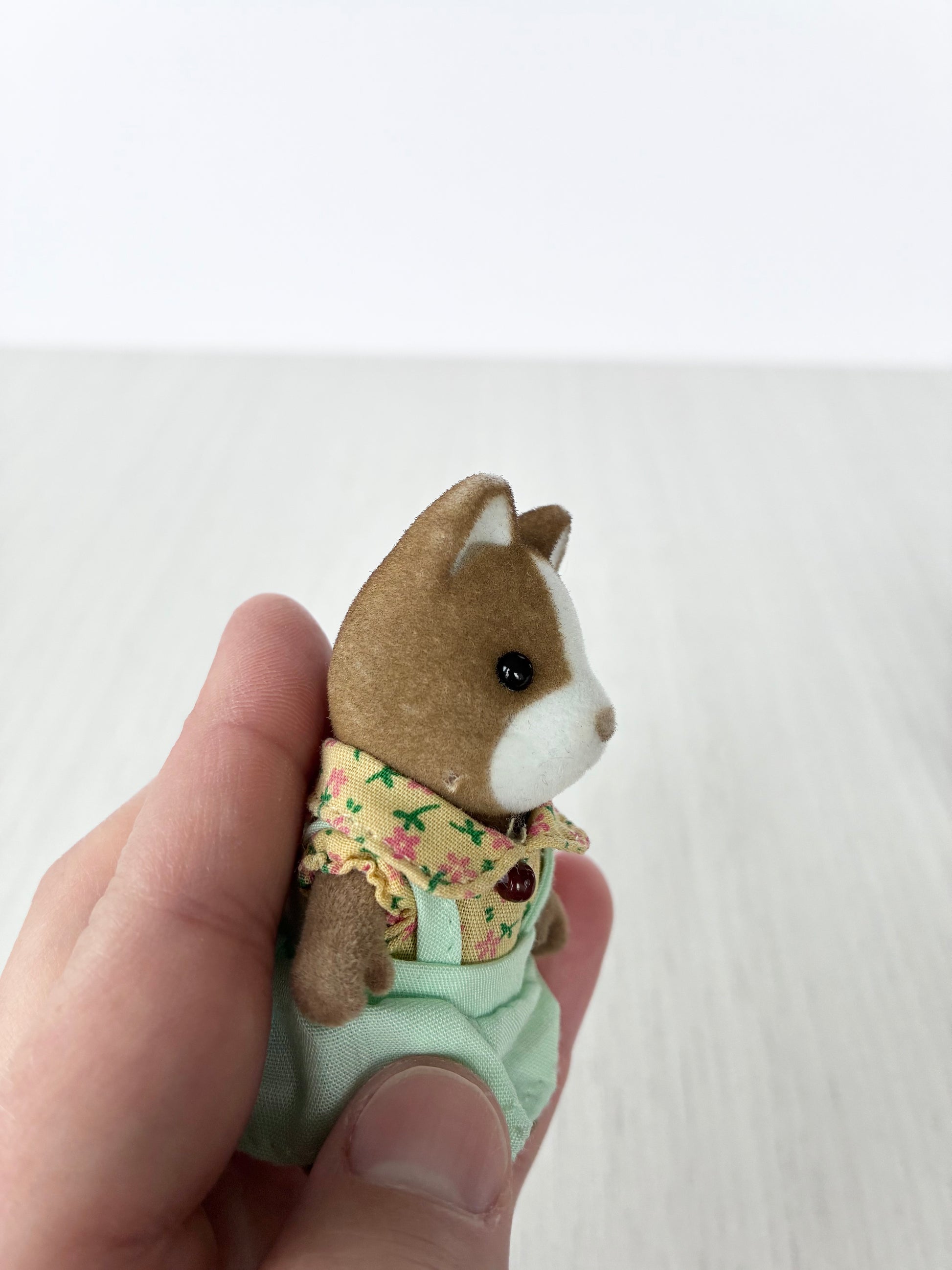 Close view of Calico Critters Sylvanian Families hound dog child in floral outfit
