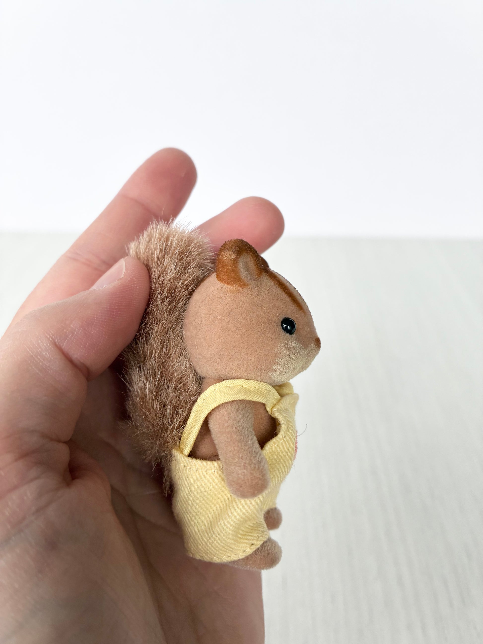 Calico Critters Sylvanian Families squirrel baby figure held in hand