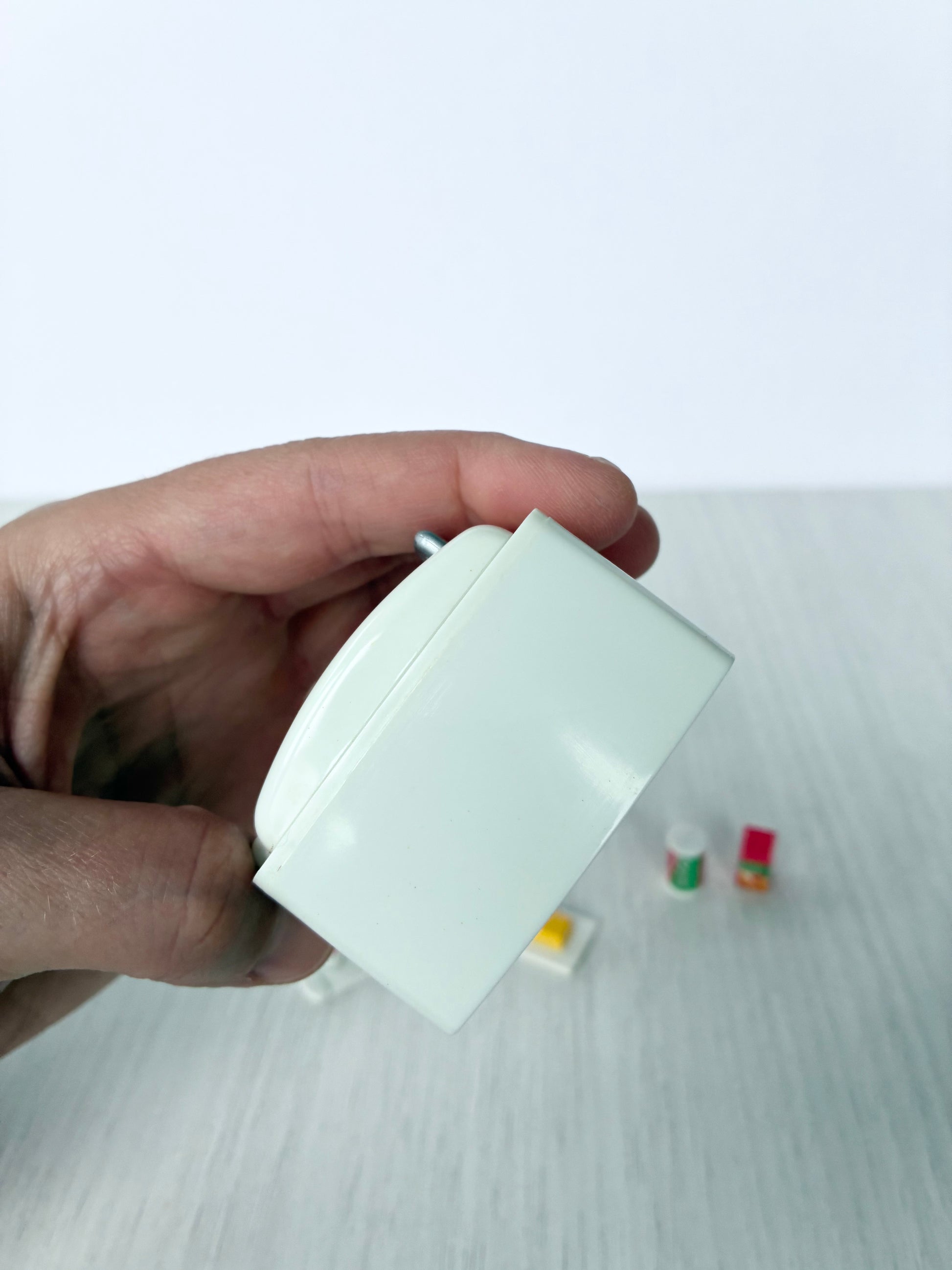 Calico Critters Sylvanian Families fridge held in hand, angled view