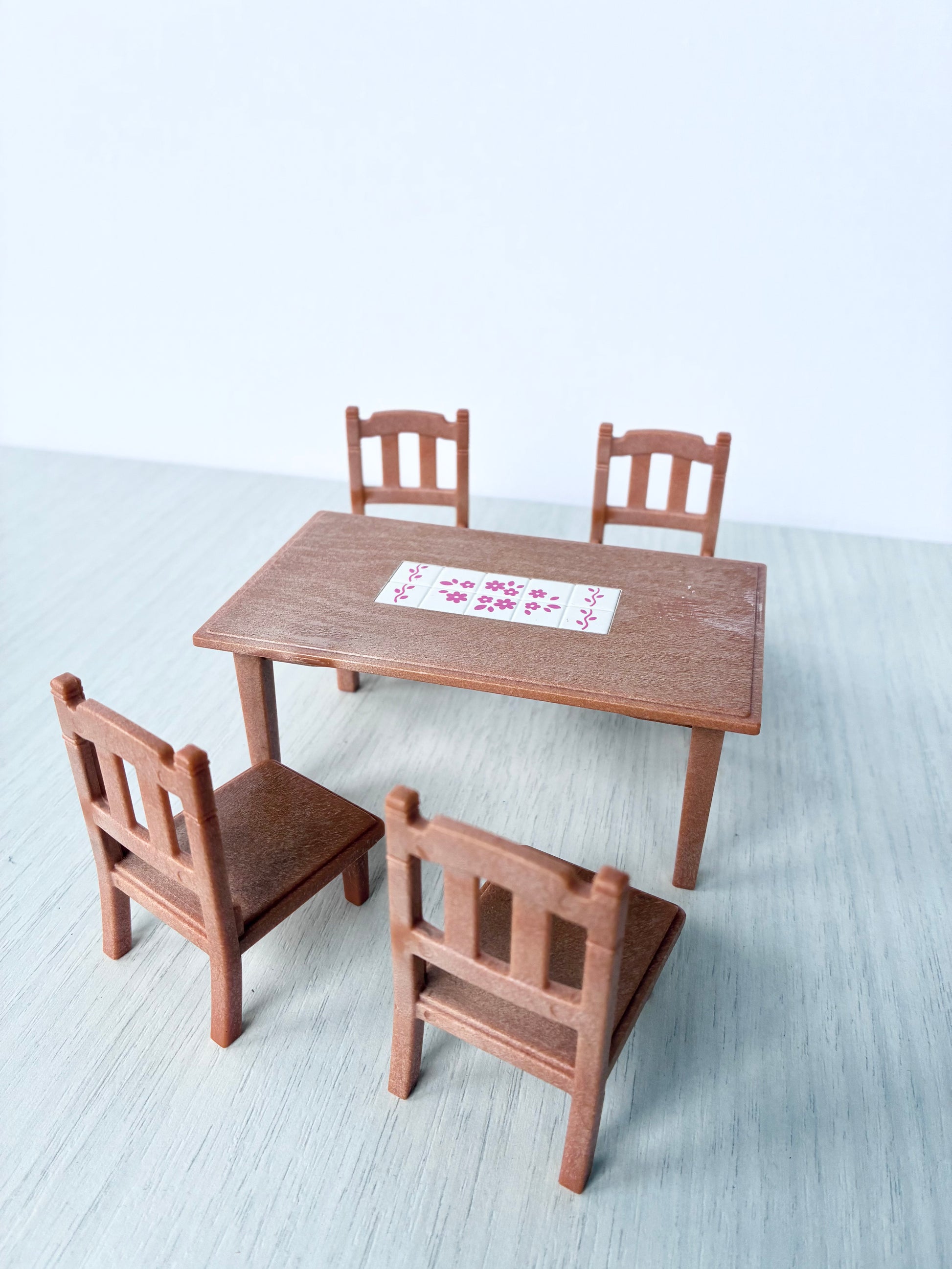 Calico Critters Sylvanian Families dining table with pink floral tile top and four matching wooden chairs