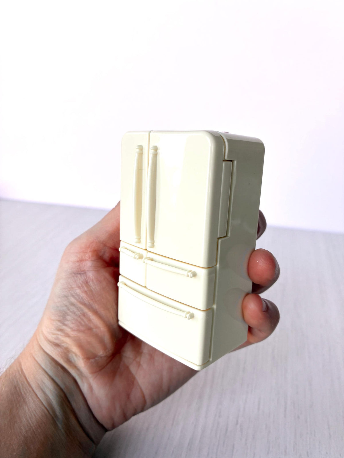 Miniature dollhouse fridge freezer, Calico Critters Kitchen Play Set, Sylvanian Families - closed fridge held in hand for scale