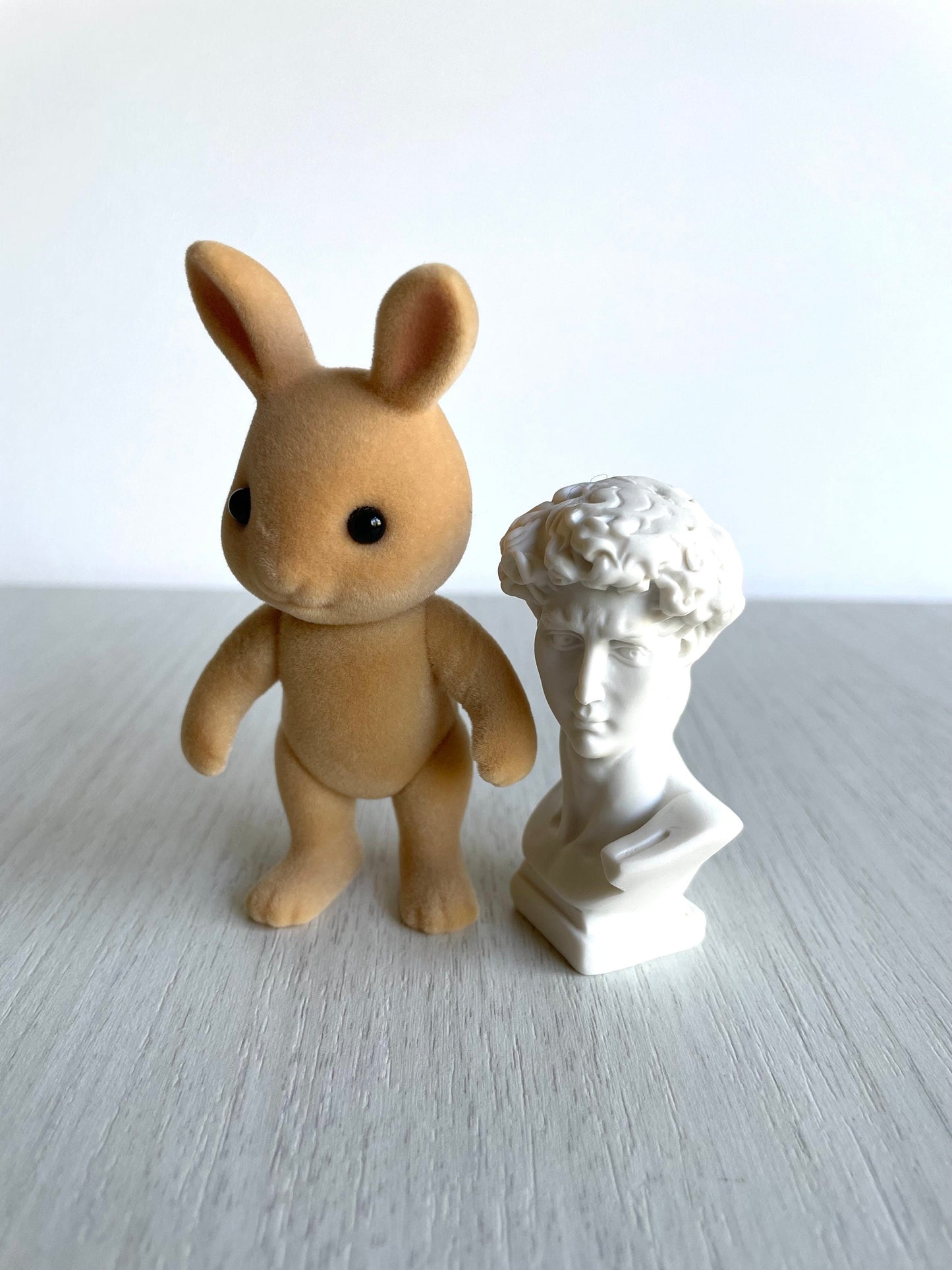 Mini head sculpture next to Calico Critters Sunny rabbit adult for scale. This small ceramic figurine adds the perfect halloween vibed museum touch!