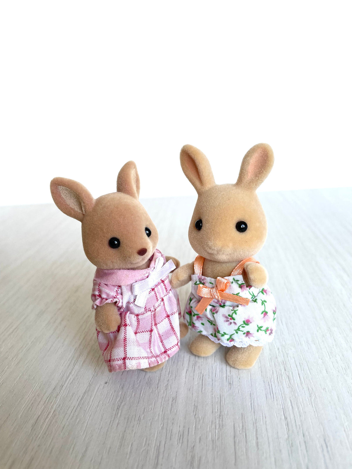 Kangaroo girl and Sunny rabbit sister stand together brand new out of box. The rabbit is wearing the cuddle bear dress. — Calico Critters / Sylvanian Families
