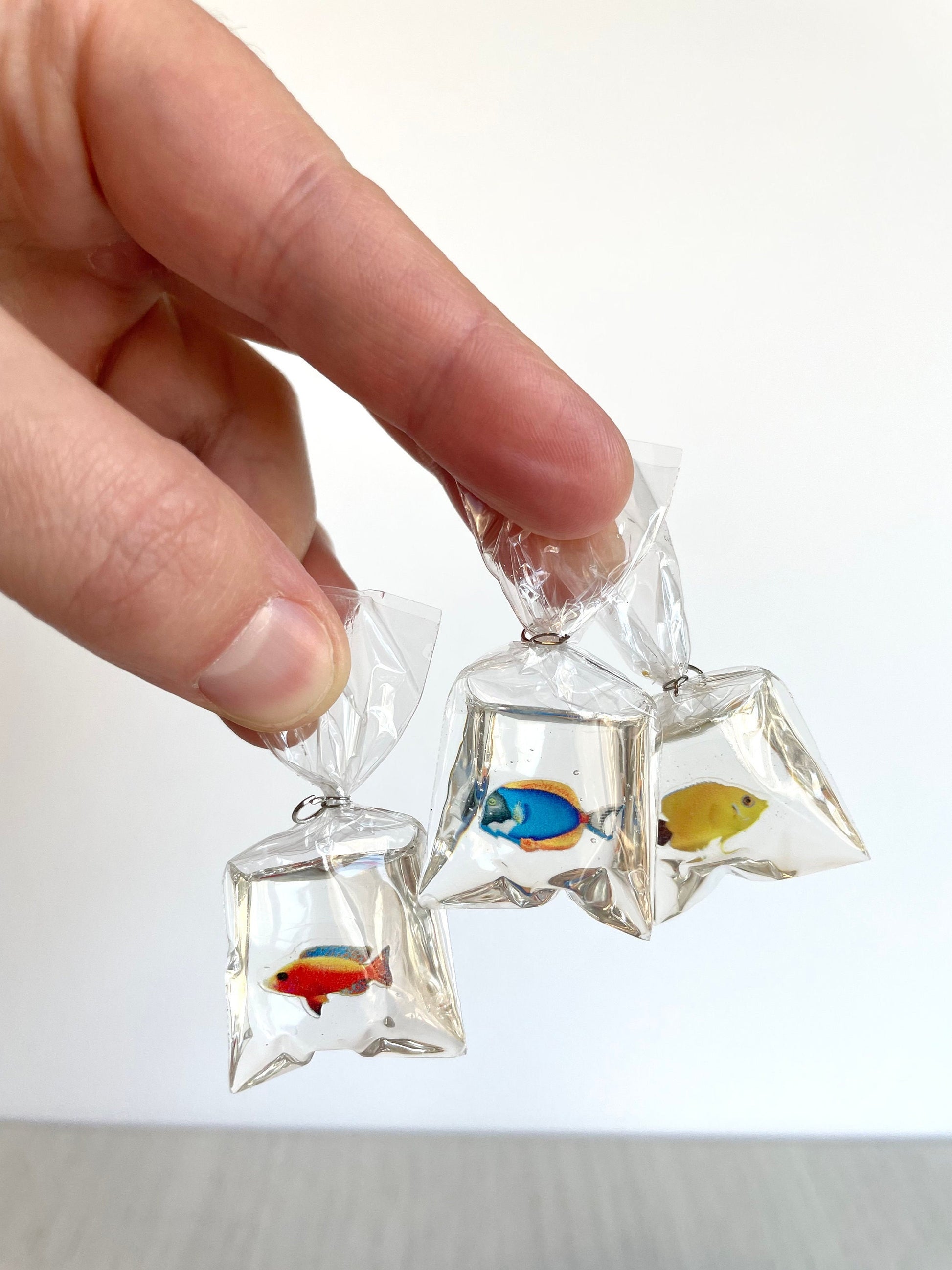 Miniature pet fish in a clear plastic bag with resin that looks like water. 1:12 scale dollhouse figurine tiny animal. Miniature fish in a clear plastic bag, perfect for dollhouse decor, DIY crafting, and Sylvanian Families scenes