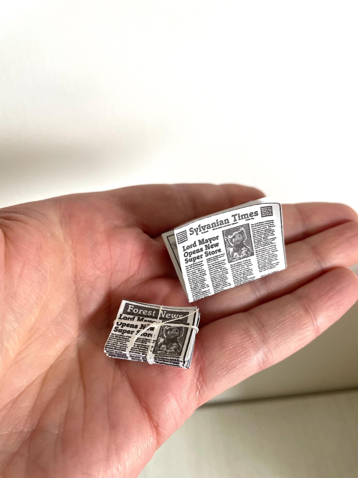 Handmade miniature newspapers for dollhouses and Calico Critters, perfect for enhancing tiny scenes and imaginative play. Ideal 1:12 scale accessories for collectors and kids alike. Elevate your dollhouse decor with these detailed newspaper prints!