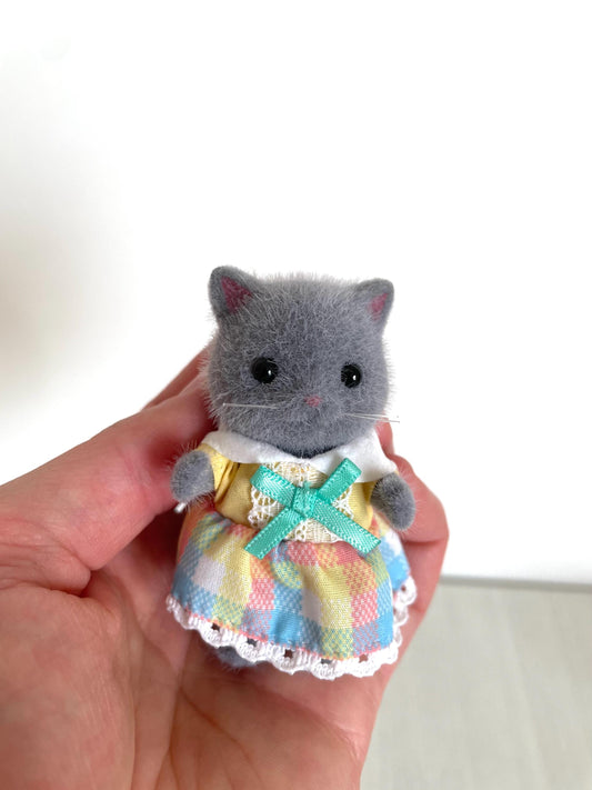 Calico Critters Persian Cat collectible figurine with posable arms and legs, perfect for collectors and fans of miniature animal toys. Features removable clothing for outfit changes and display customization. A detailed, high-quality Sylvanian Families figure ideal for dollhouse scenes, dioramas, or miniature collections.