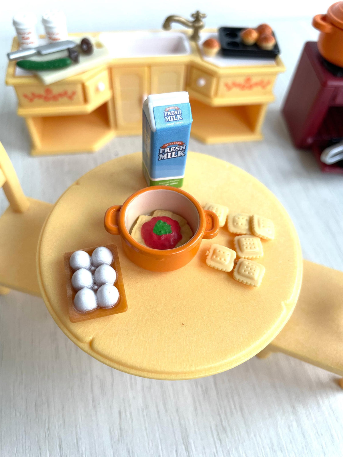 Round kitchen table laid with milk carton, eggs, salad plate and bread rolls, vintage Calico Critters Sylvanian Families kitchen