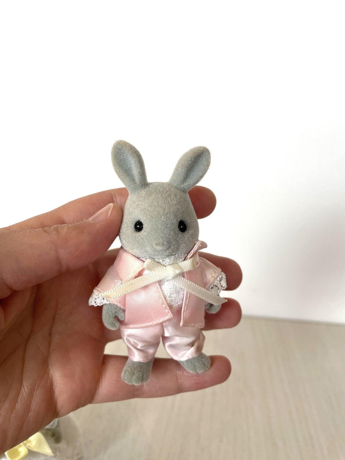Grey rabbit groom in pink satin wedding suit held in hand for scale — Calico Critters and Sylvanian Families