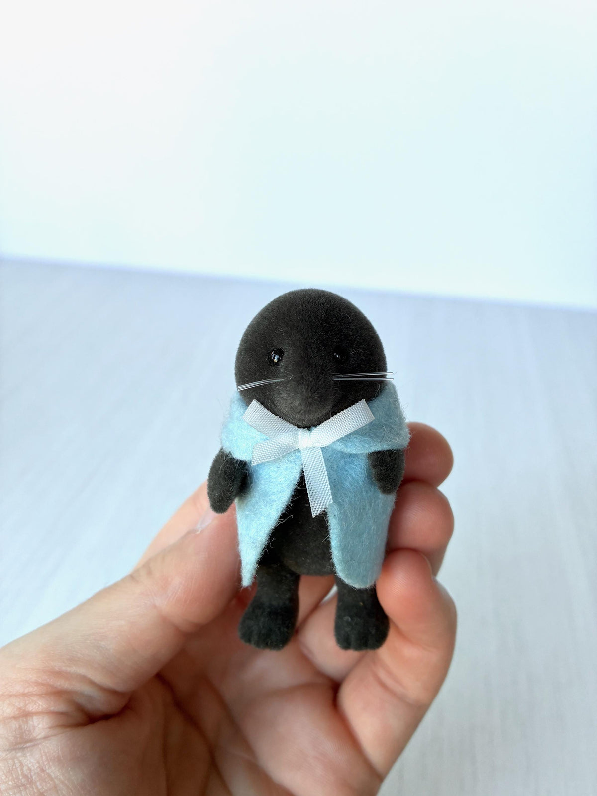 Calico Critters Sylvanian Families vintage McBurrows mole family, mother mole in her blue felt cape with white ribbon, held in hand for scale