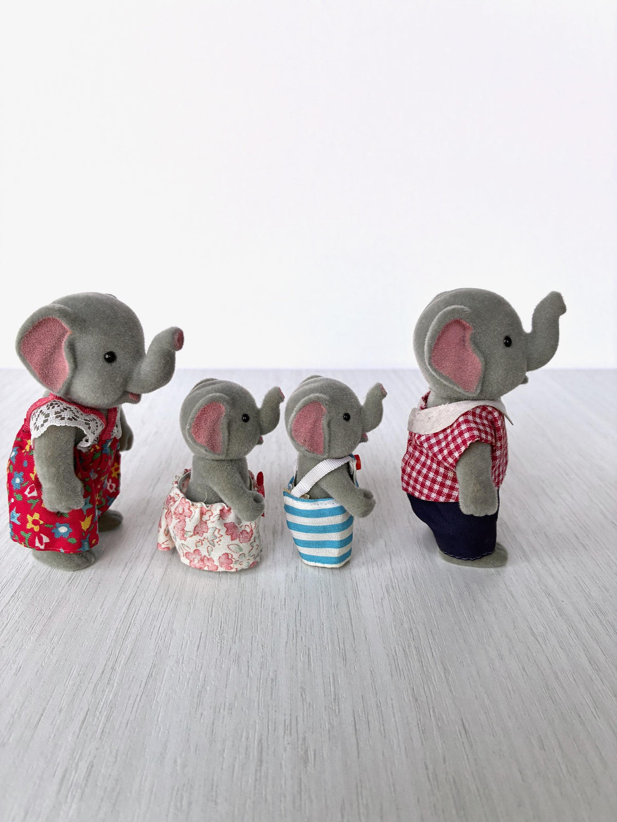 Vintage Forest Families elephant family of four standing together, side angle showing trunks and pink ears