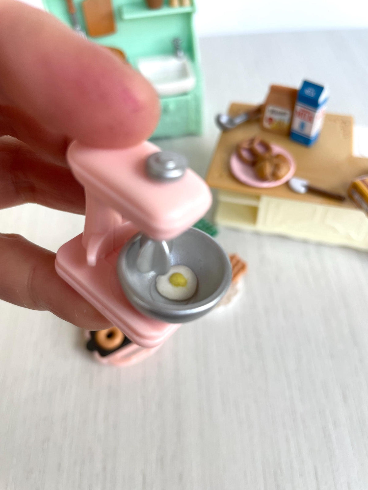 Pink stand mixer held in hand for scale, bowl with cracked egg — Calico Critters and Sylvanian Families