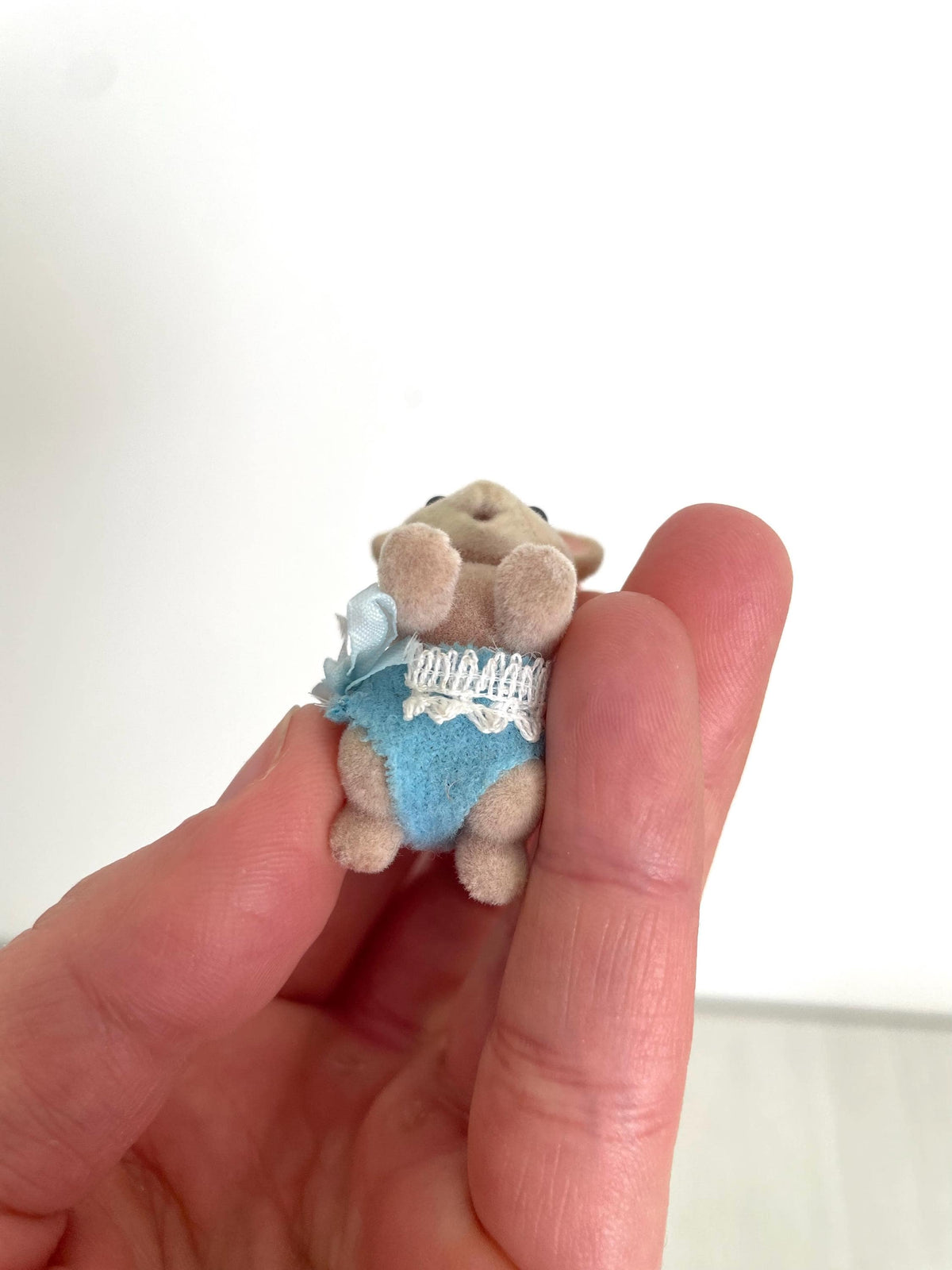 Overhead view of the Maces Mouse baby boy held between fingers — Calico Critters and Sylvanian Families
