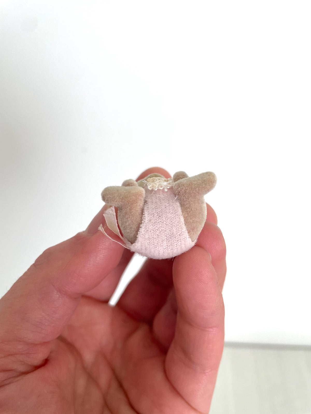 Overhead view of the Maces Mouse baby girl held between fingers — Calico Critters and Sylvanian Families