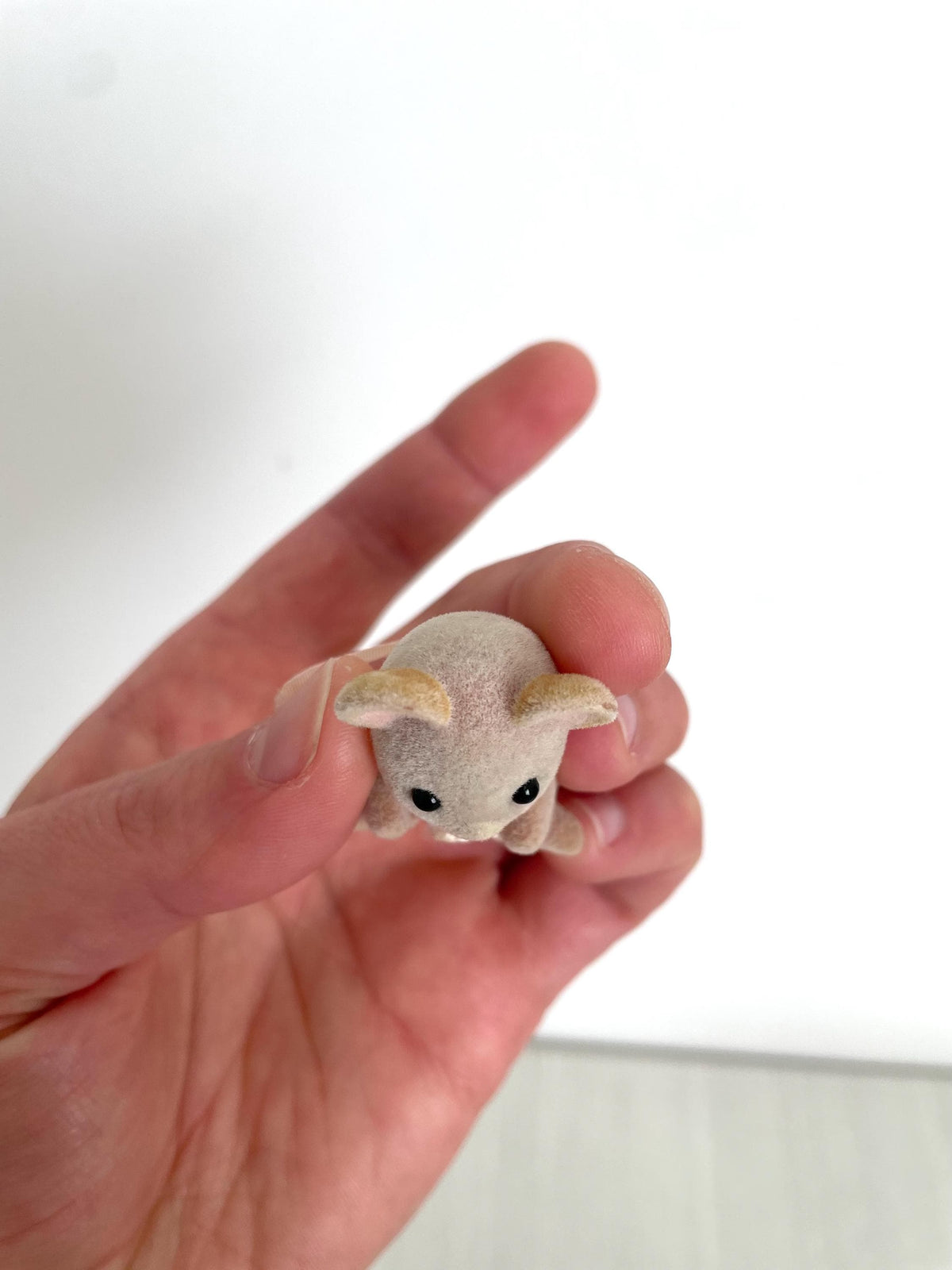 Close-up of the Maces Mouse baby girl's face held in hand — Calico Critters and Sylvanian Families