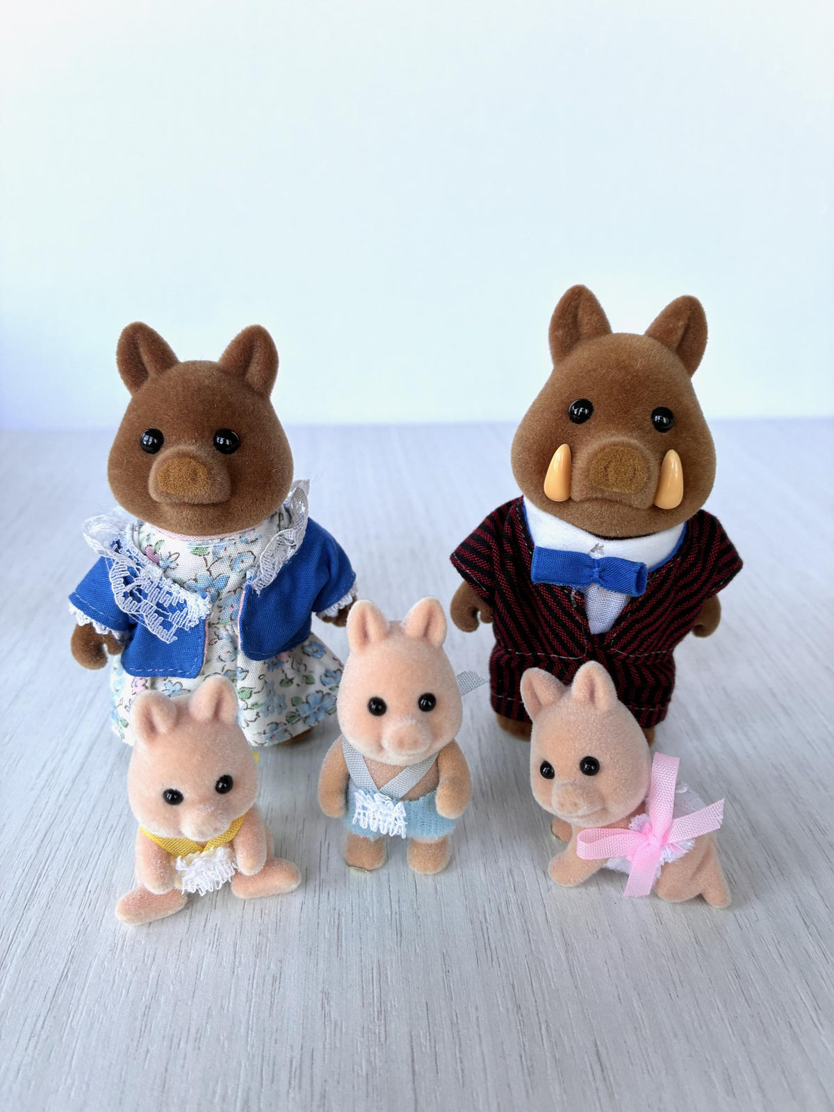 Sylvanian Families Calico Critters Wild Boar Family (Flair, boxed): Mum in blue floral dress and jacket, Dad in burgundy pinstripe suit, babies in yellow, blue and pink rompers