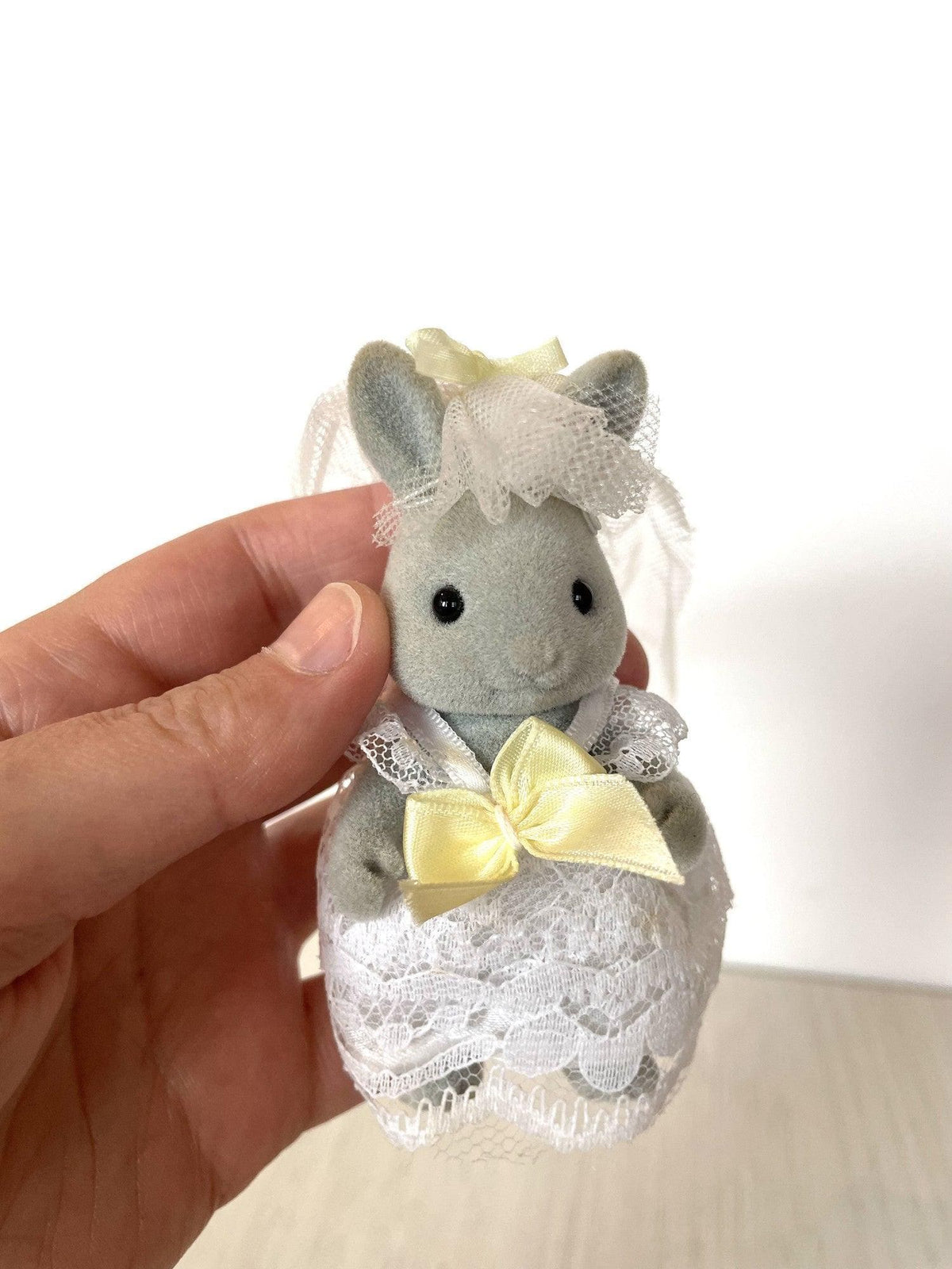 Grey rabbit bride in white lace gown and tulle veil held in hand for scale — Calico Critters and Sylvanian Families