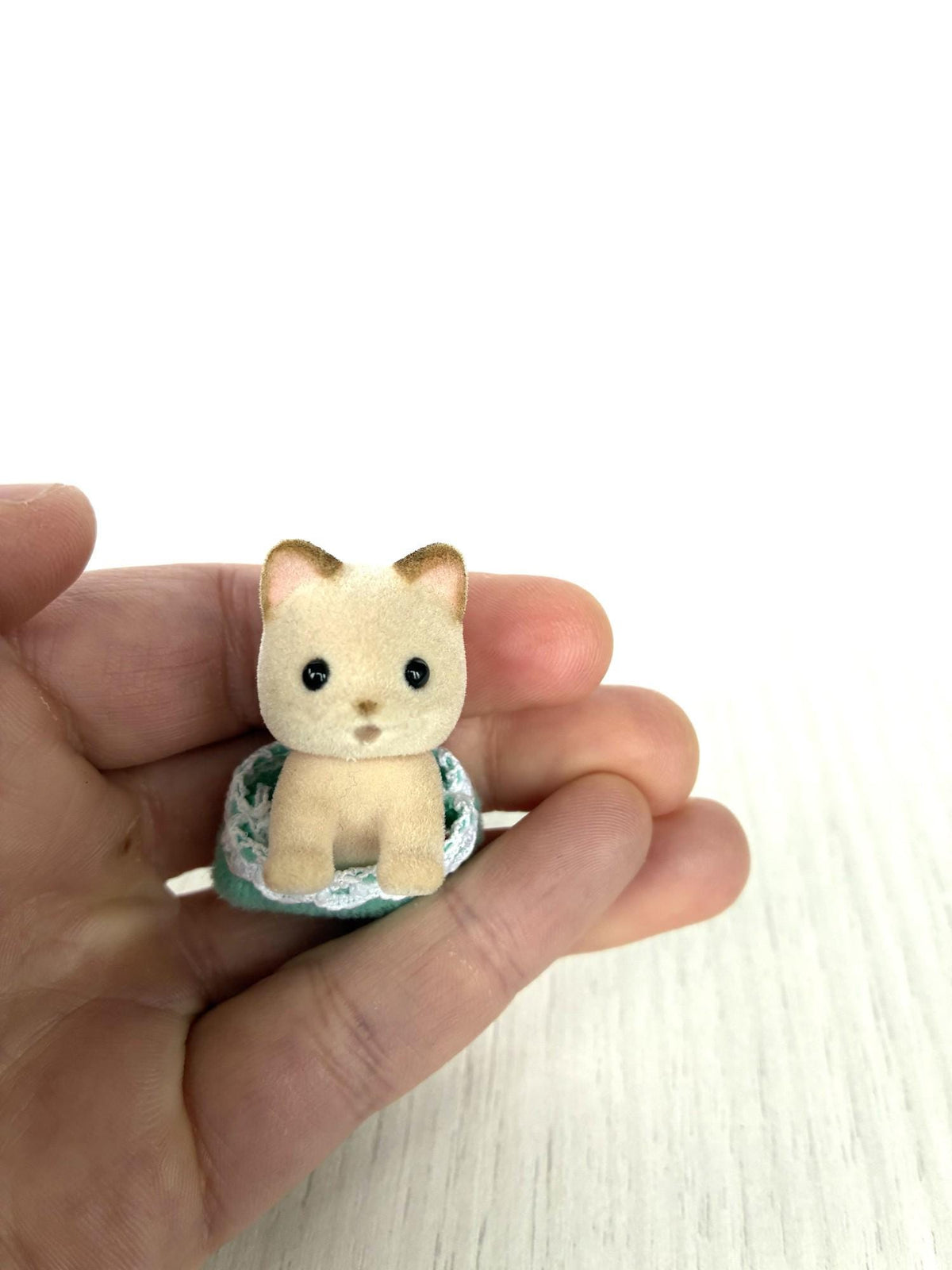 Calico Critters Sylvanian Families cream cat crawling baby in mint green romper held in hand, Keats cat baby