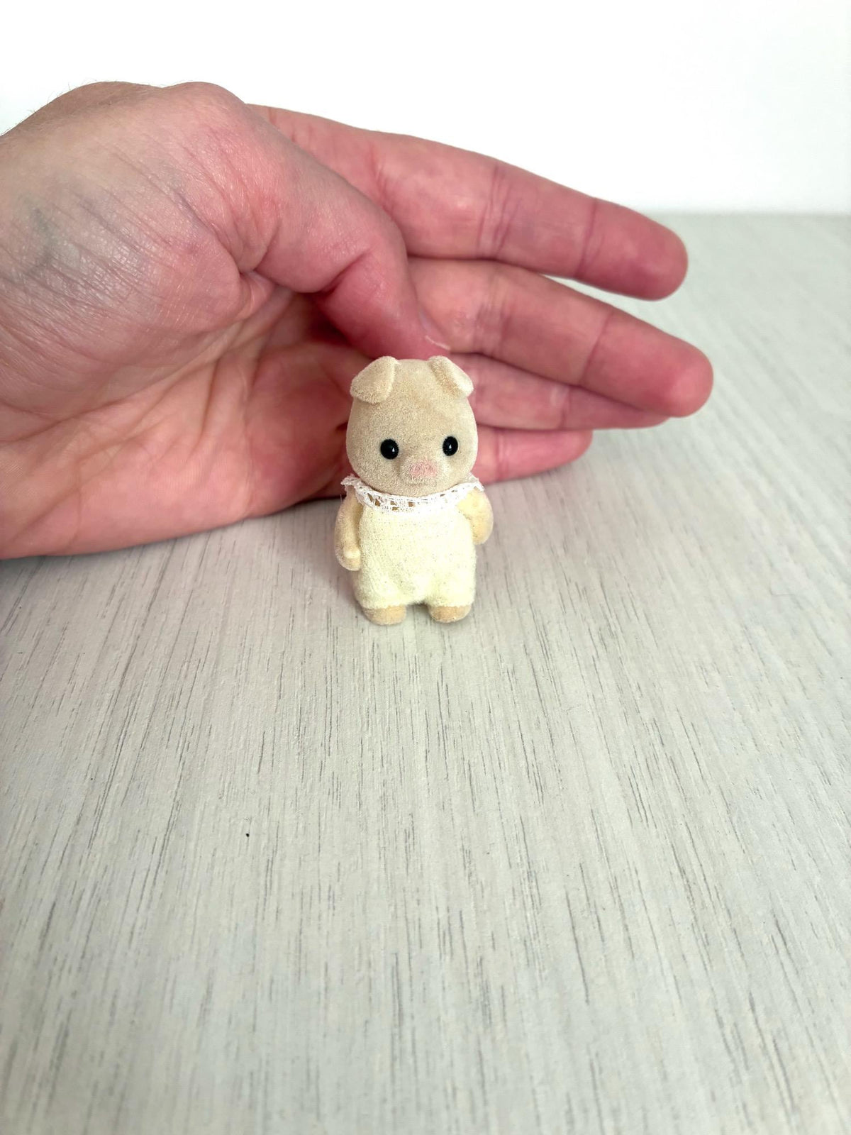 Calico Critters Sylvanian Families vintage piglet baby figure, front view in hand