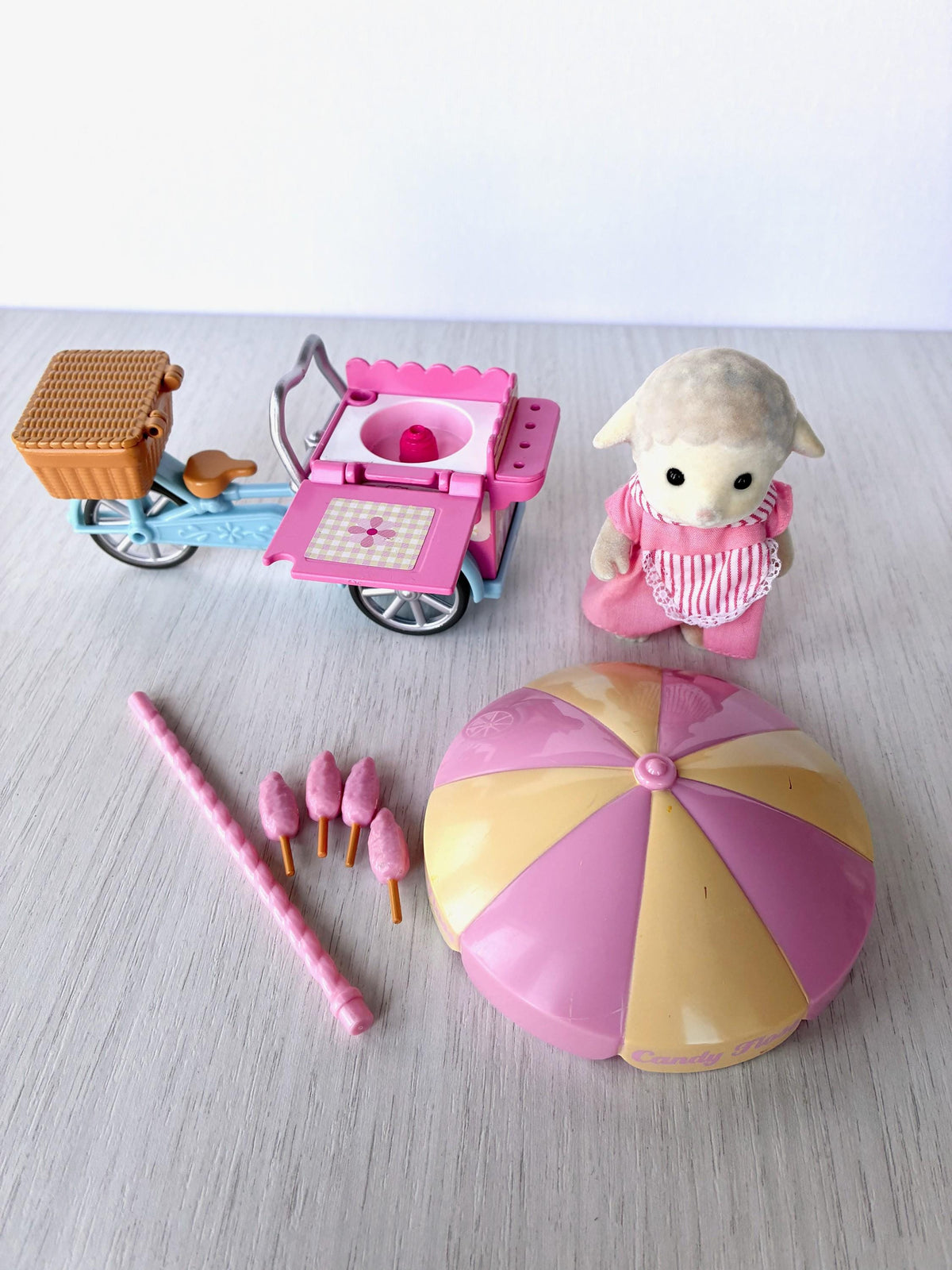 Sylvanian Families Calico Critters Dolly's Candy Floss (Flair 4678) all pieces laid out: tricycle cart, Dolly Dale, umbrella canopy and pole, four candy flosses