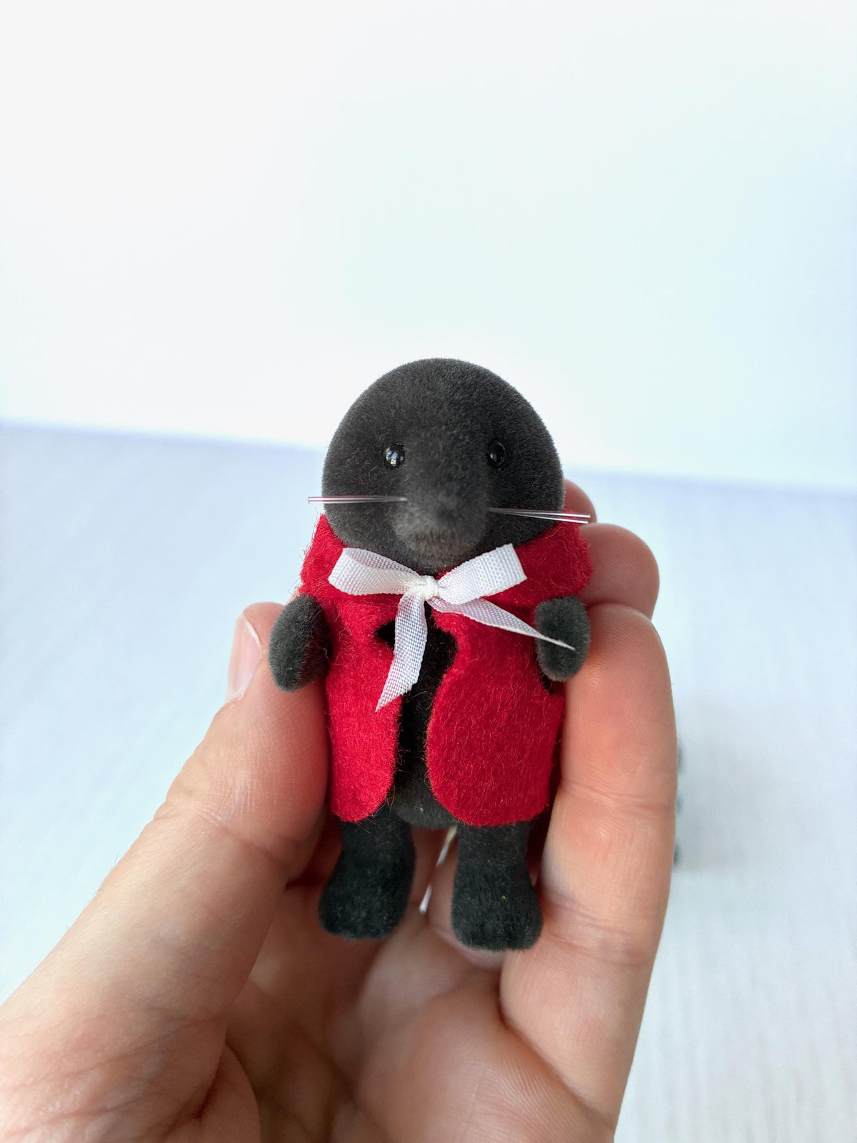 Calico Critters Sylvanian Families vintage McBurrows mole family, father mole in his red felt cape with white ribbon, held in hand for scale
