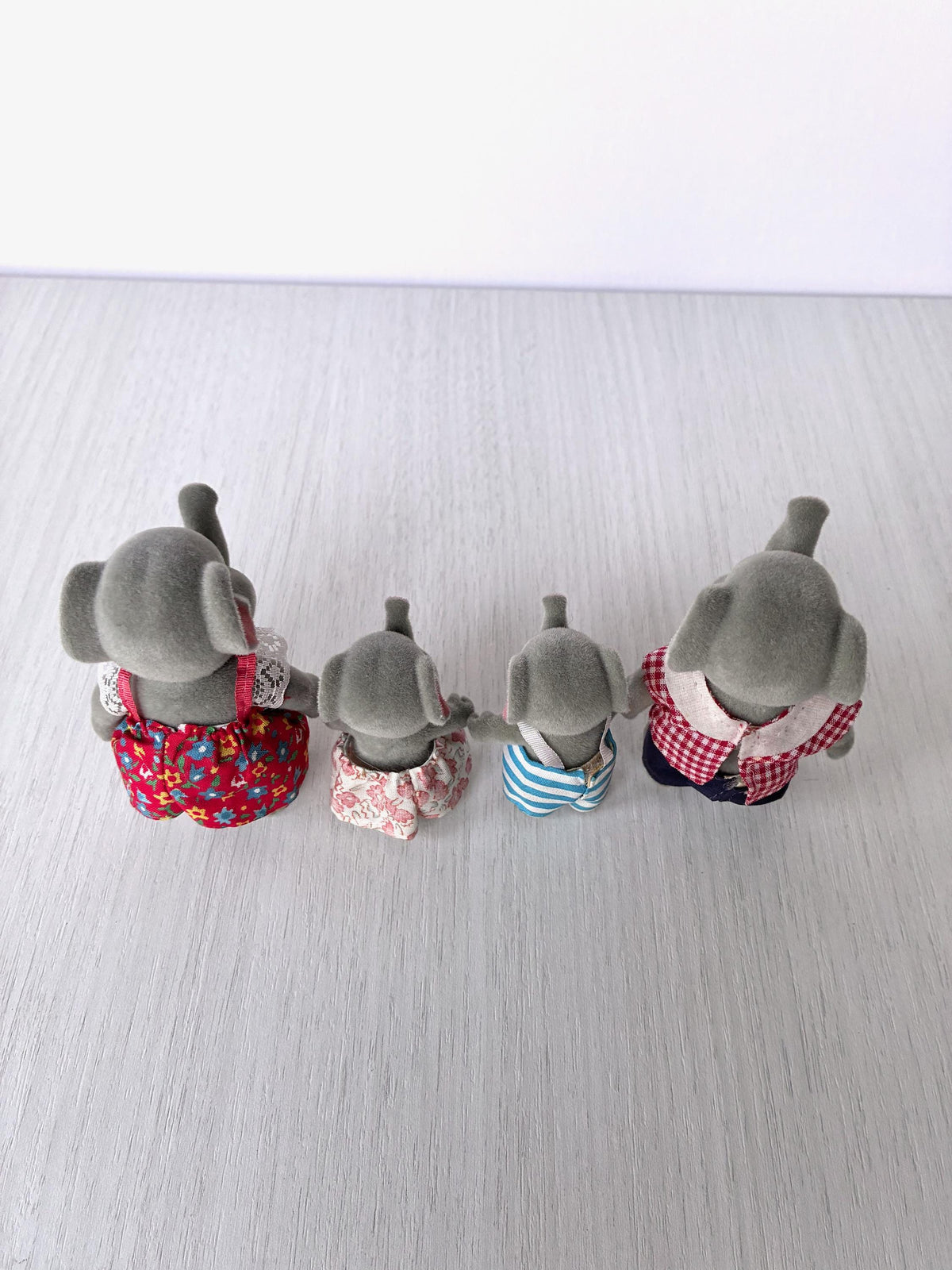 Angled back view of the vintage Forest Families Bärenwald elephant family of four showing outfits and flocking
