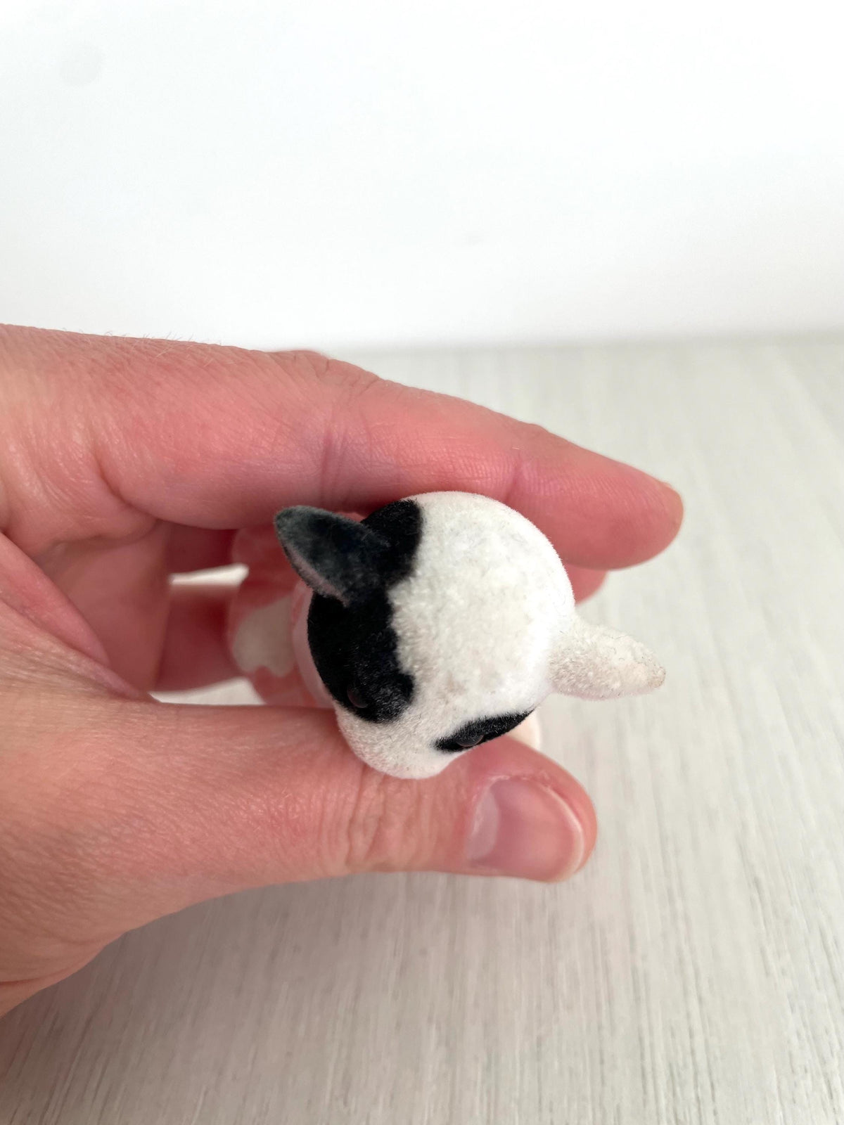 Top-down view of the cow girl face showing her black patch marking and pink ears — Calico Critters and Sylvanian Families