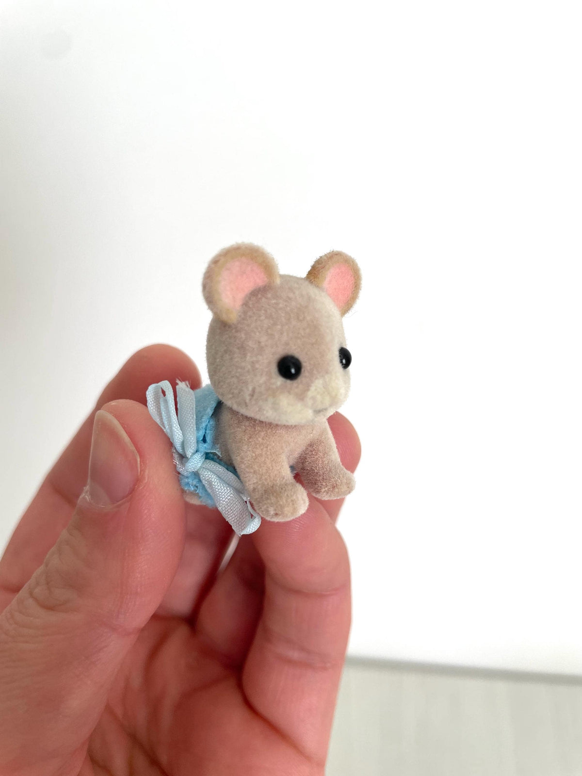 Close-up of the Maces Mouse baby boy's face held in hand — Calico Critters and Sylvanian Families