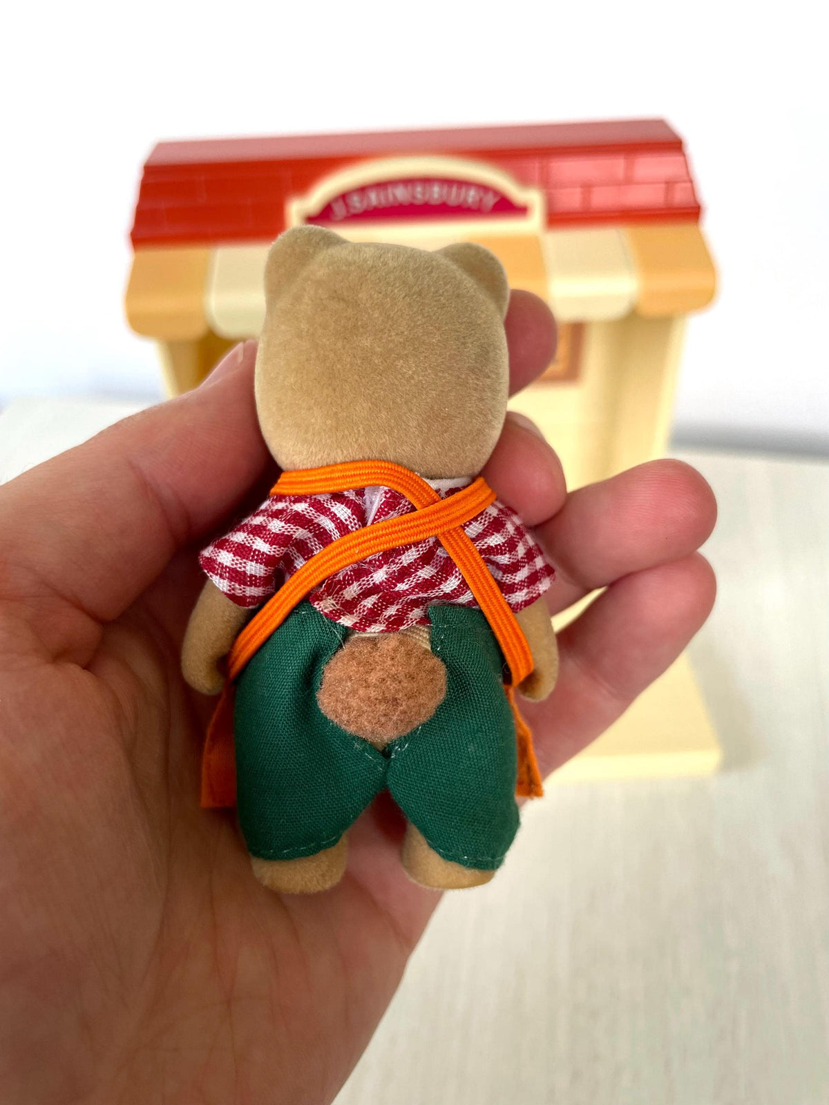 Back view of J. Sainsbury shopkeeper bear showing even flocking and green trousers, Sylvanian Families Calico Critters