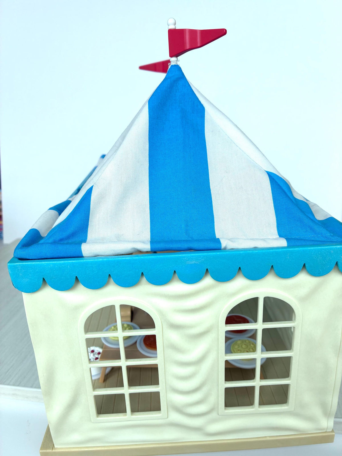 Calico Critters Sylvanian Families Marquee angled front view showing the striped tent peak, flag and scalloped trim
