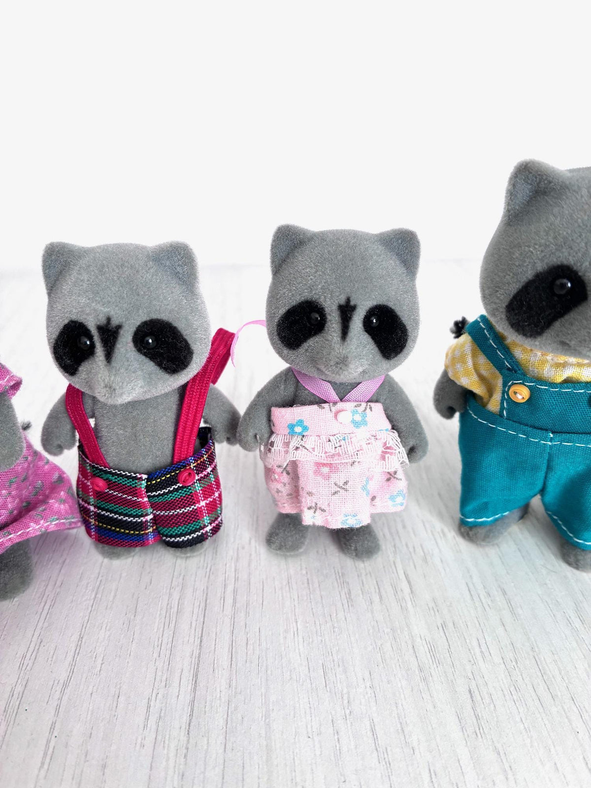 Calico Critters Sylvanian Families vintage Chestnut Raccoon family of 4, brother in tartan overalls, sister in pink floral skirt, and father in teal overalls