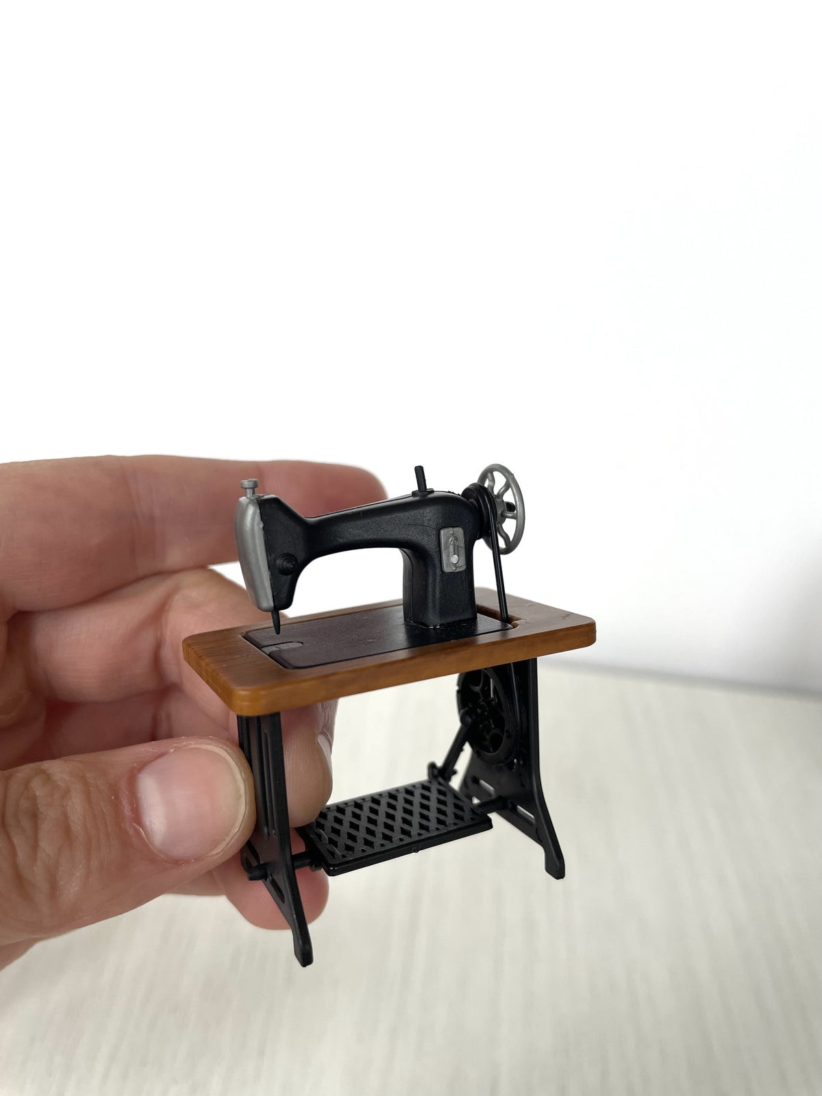 Vintage treadle sewing machine with wooden top held in hand for scale — Calico Critters and Sylvanian Families