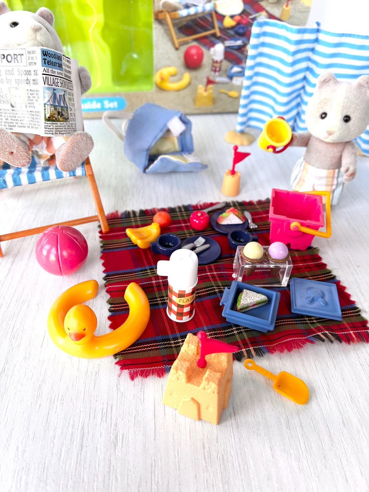 Sylvanian Families Calico Critters Day at the Seaside Set (Flair 4870): Harley reading in the deck chair, Vespa with bucket, picnic rug with food in front of the Flair box