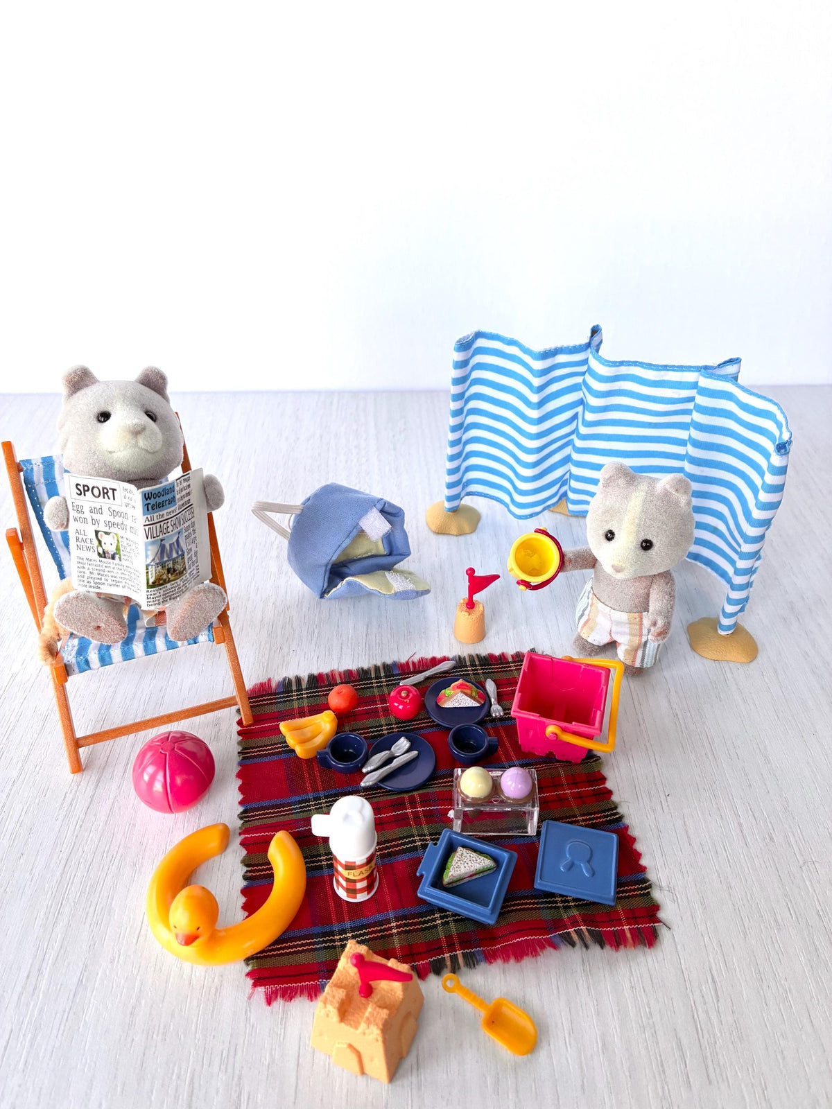 Sylvanian Families Calico Critters Day at the Seaside Set (Flair 4870): beach scene without the box, Harley reading in the deck chair and Vespa standing by the windbreak with his bucket