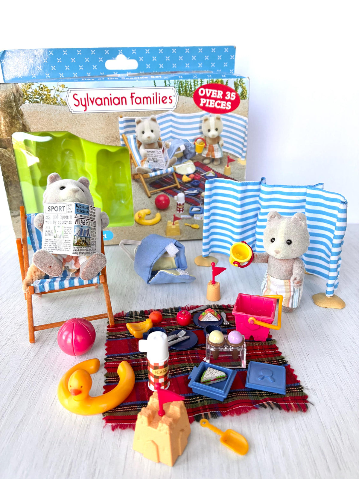 Sylvanian Families Calico Critters Day at the Seaside Set (Flair 4870): beach scene with both Farthing dog figures, deck chair and windbreak in front of the original Flair box