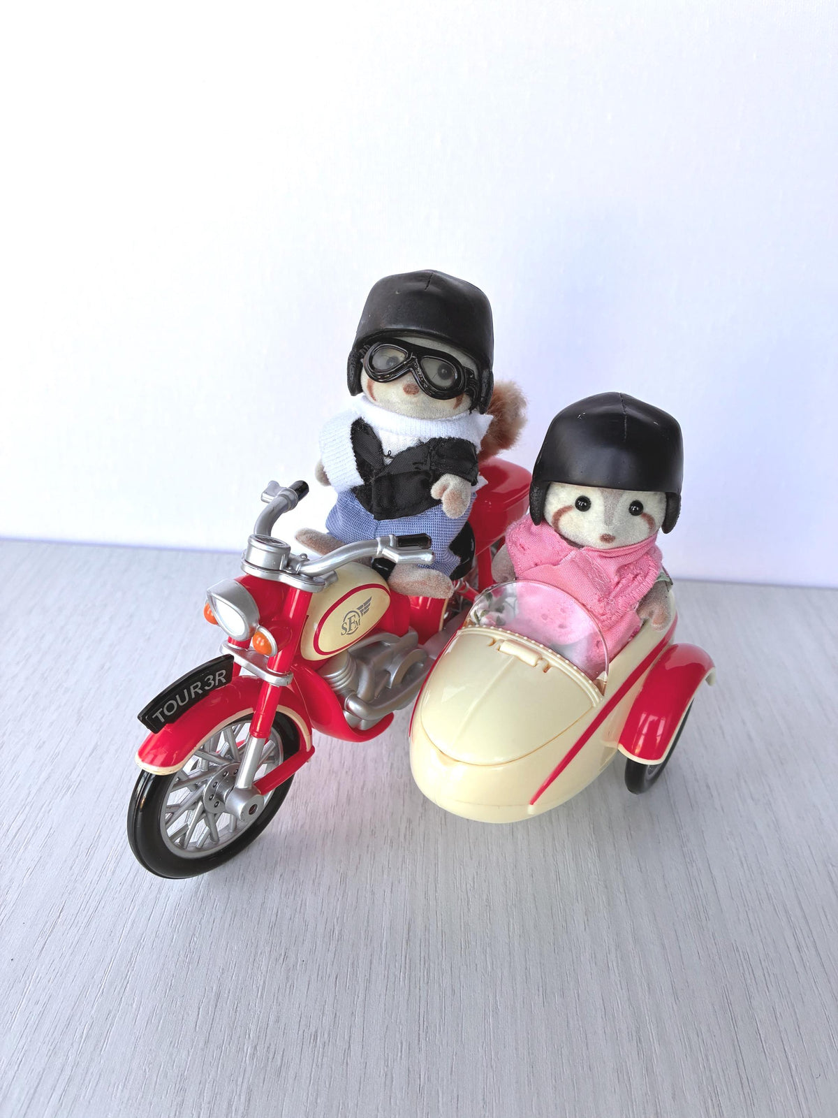 Calico Critters Sylvanian Families George Mulberry riding the red Motorcycle with Mildred seated in the cream Sidecar, both wearing helmets