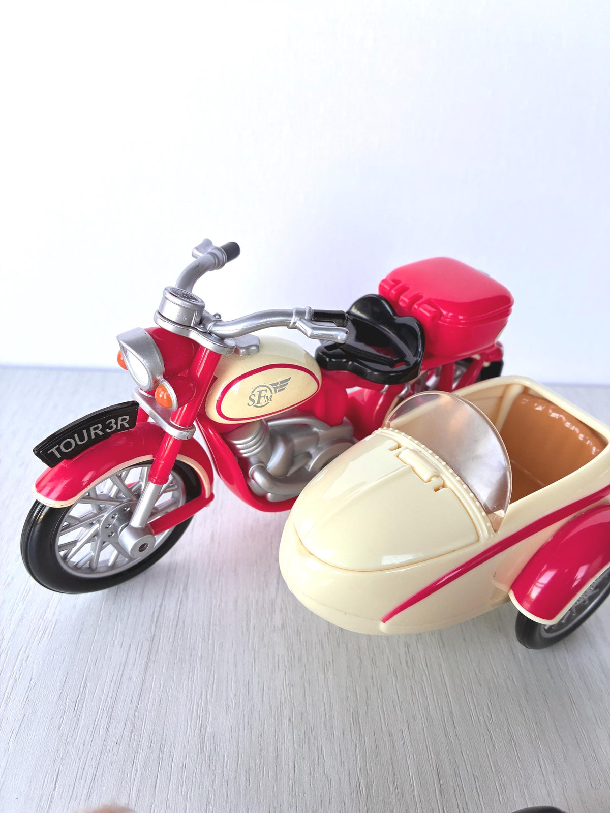 Calico Critters Sylvanian Families red and cream Motorcycle with Sidecar, front view showing headlight, cream fuel tank with wings logo, clear windscreen and TOUR 3R plate